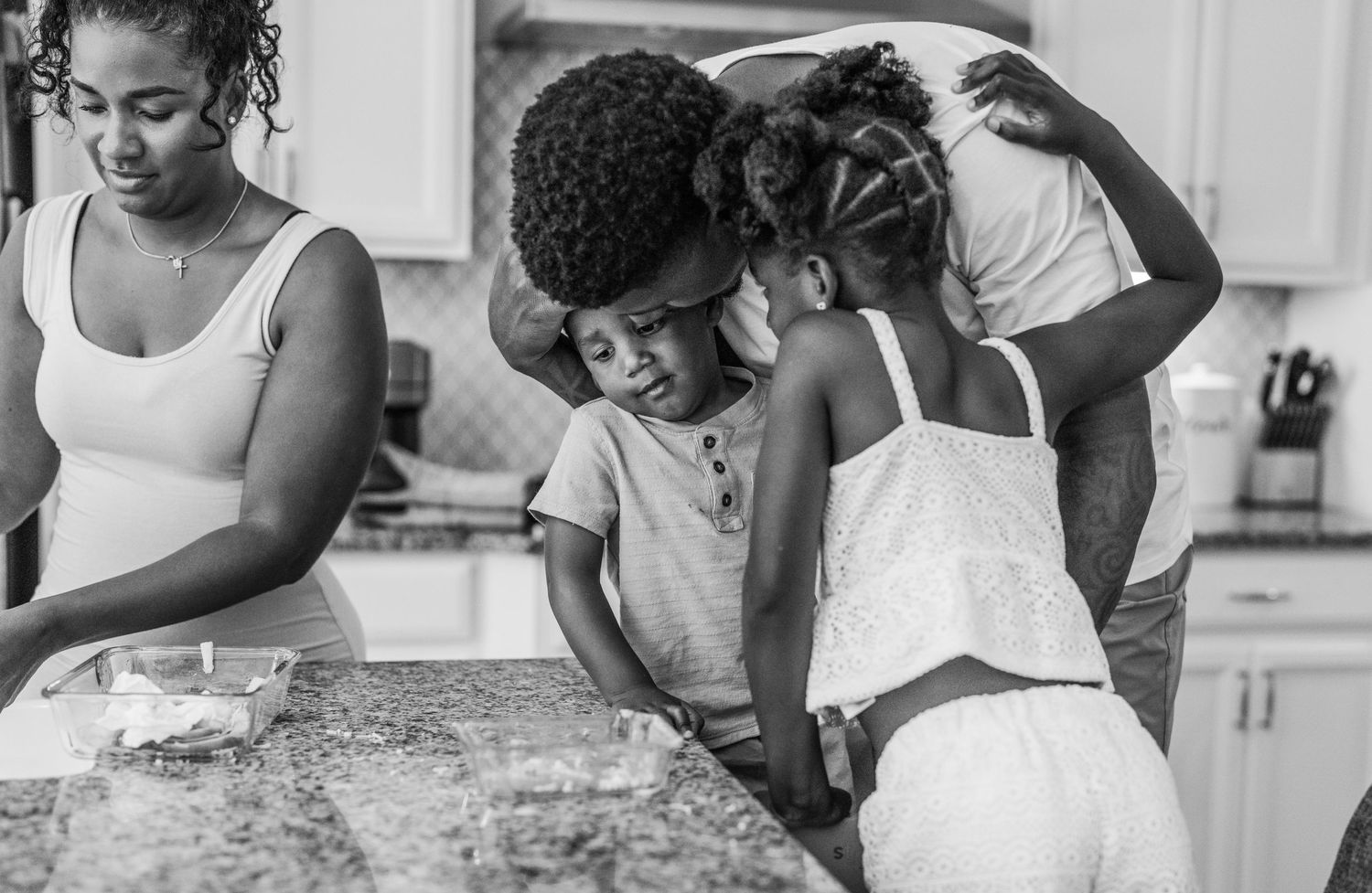 A heartwarming black and white kitchen scene captures tender family bonding moments while baking together.