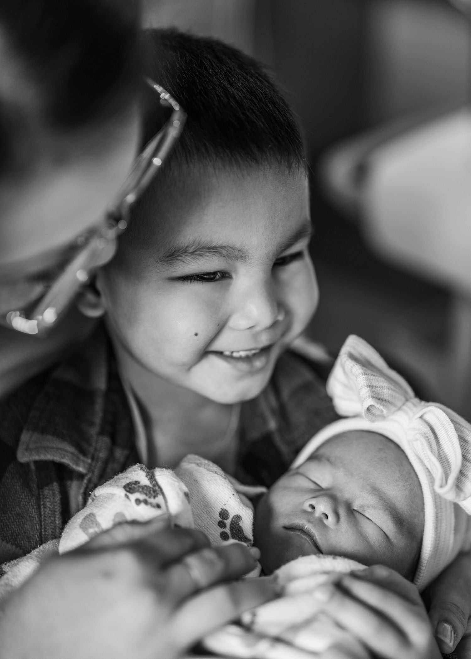 A montage of black and white intimate photographs showing tender parent-child moments and interactions.