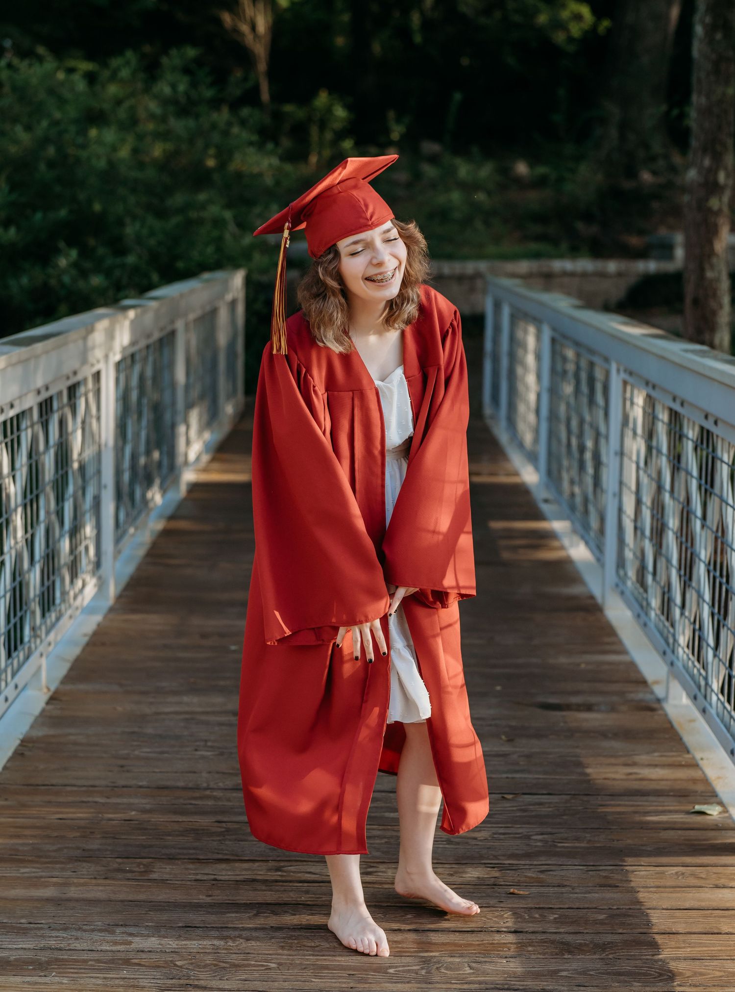 A series of photos showing someone in a bright red blazer and hat posing playfully on a wooden bridge in nature.