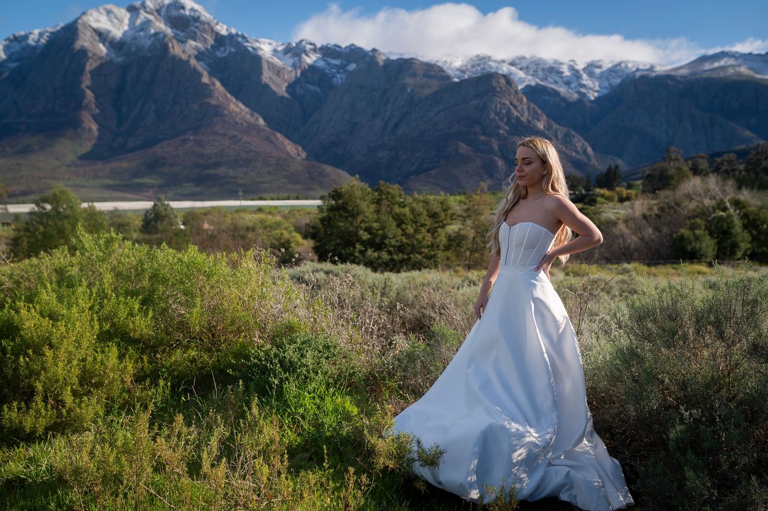 A flowing white wedding dress twirls against a dramatic mountain landscape in Paradise Valley, Montana.