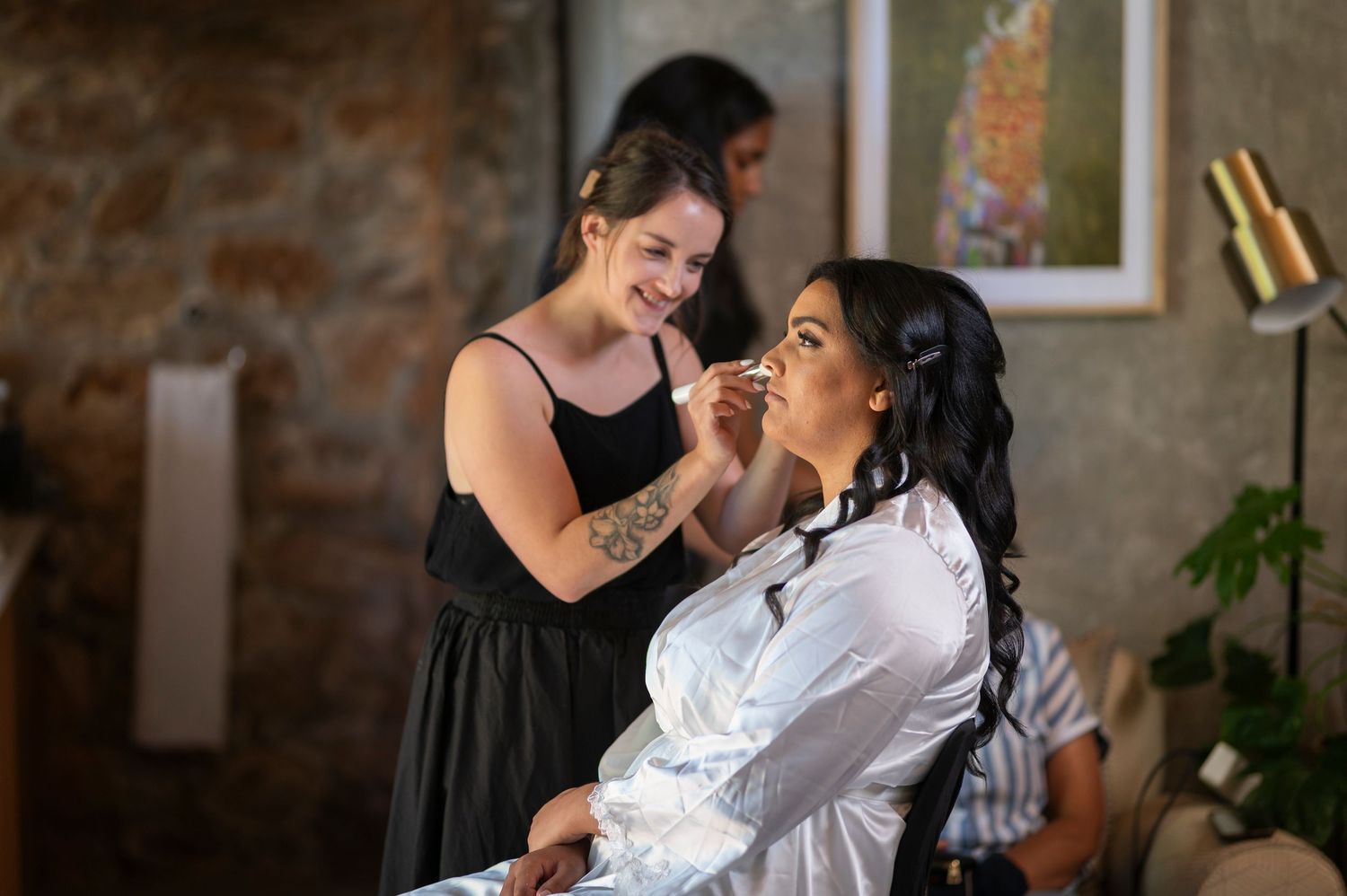 A couple shares a tender moment during a dance in a rustic brick-walled room.