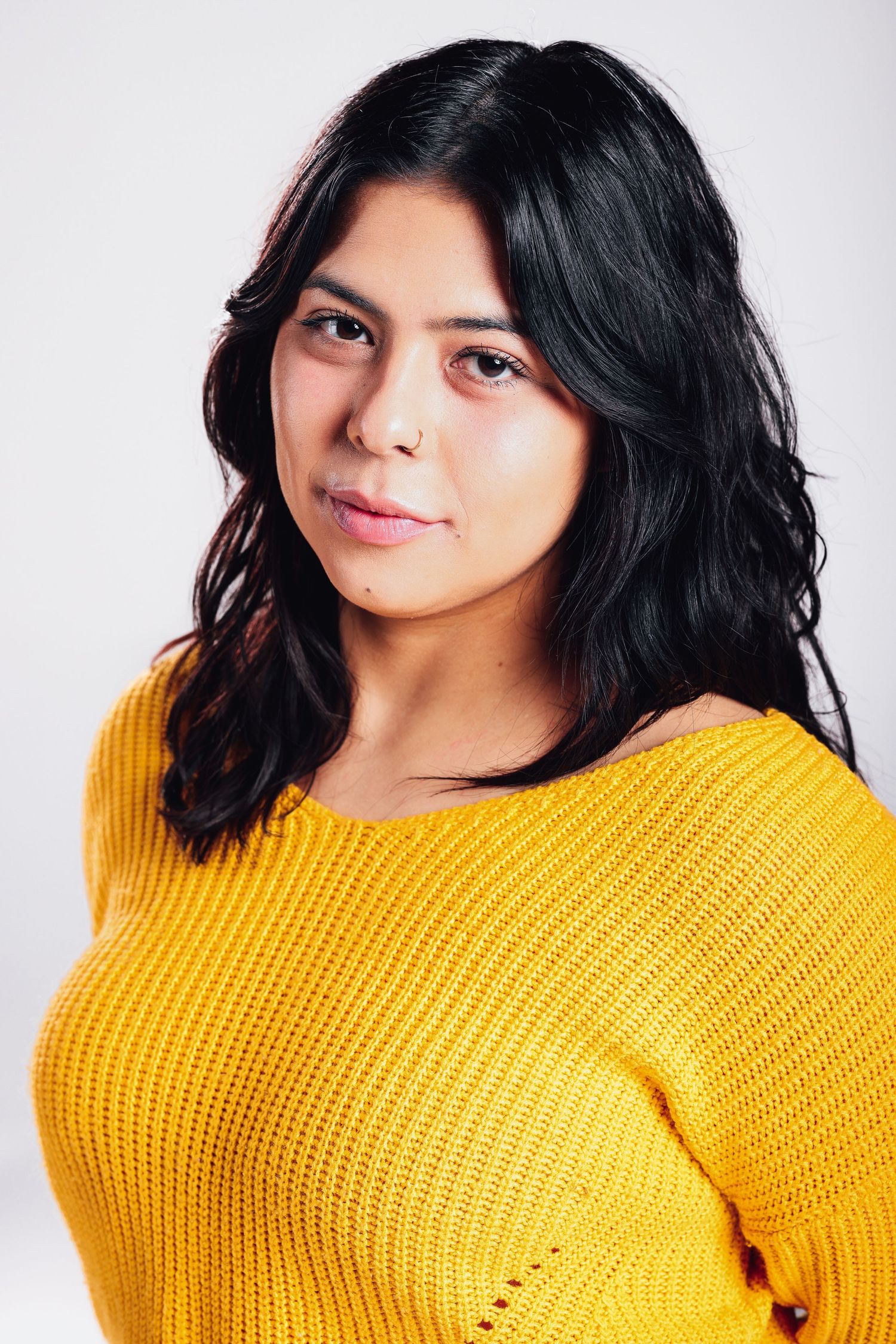 Portrait of someone wearing a bright yellow knit sweater against a light background.
