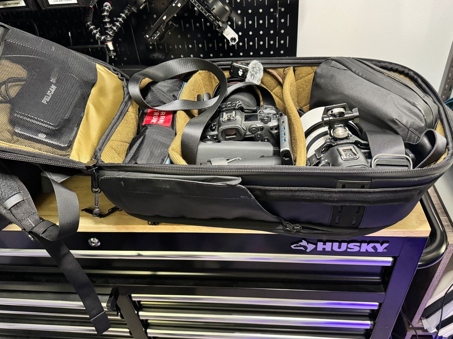 Large black Husky tool chest drawer with golf bags and equipment stored on top showing club heads and storage organization.
