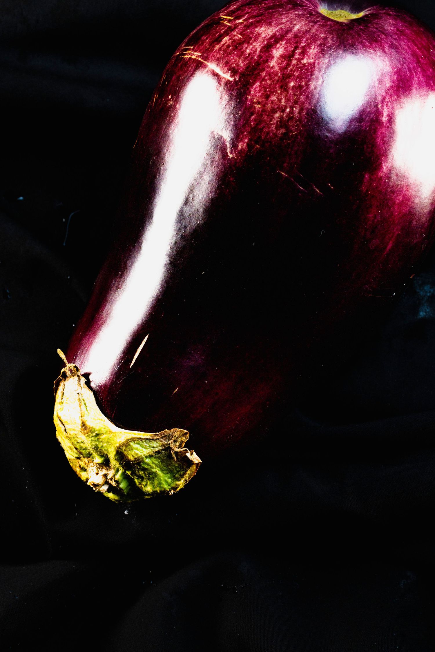 Macro photo sequence showing a droplet falling and splashing on a deep red apple surface in rich detail.