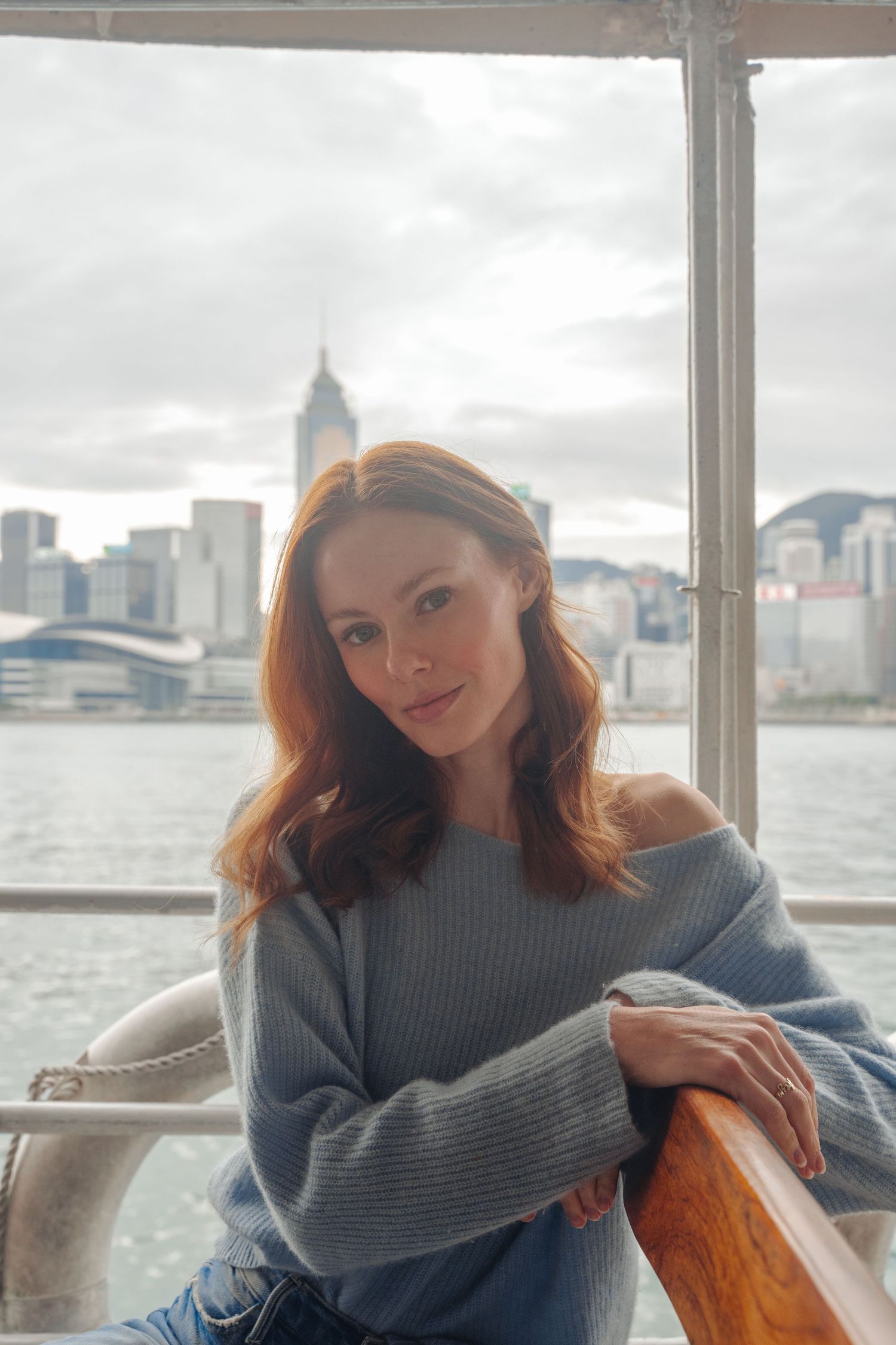 Alyssa Campanella relaxing on the Star Ferry with Hong Kong's skyline visible in the background.
