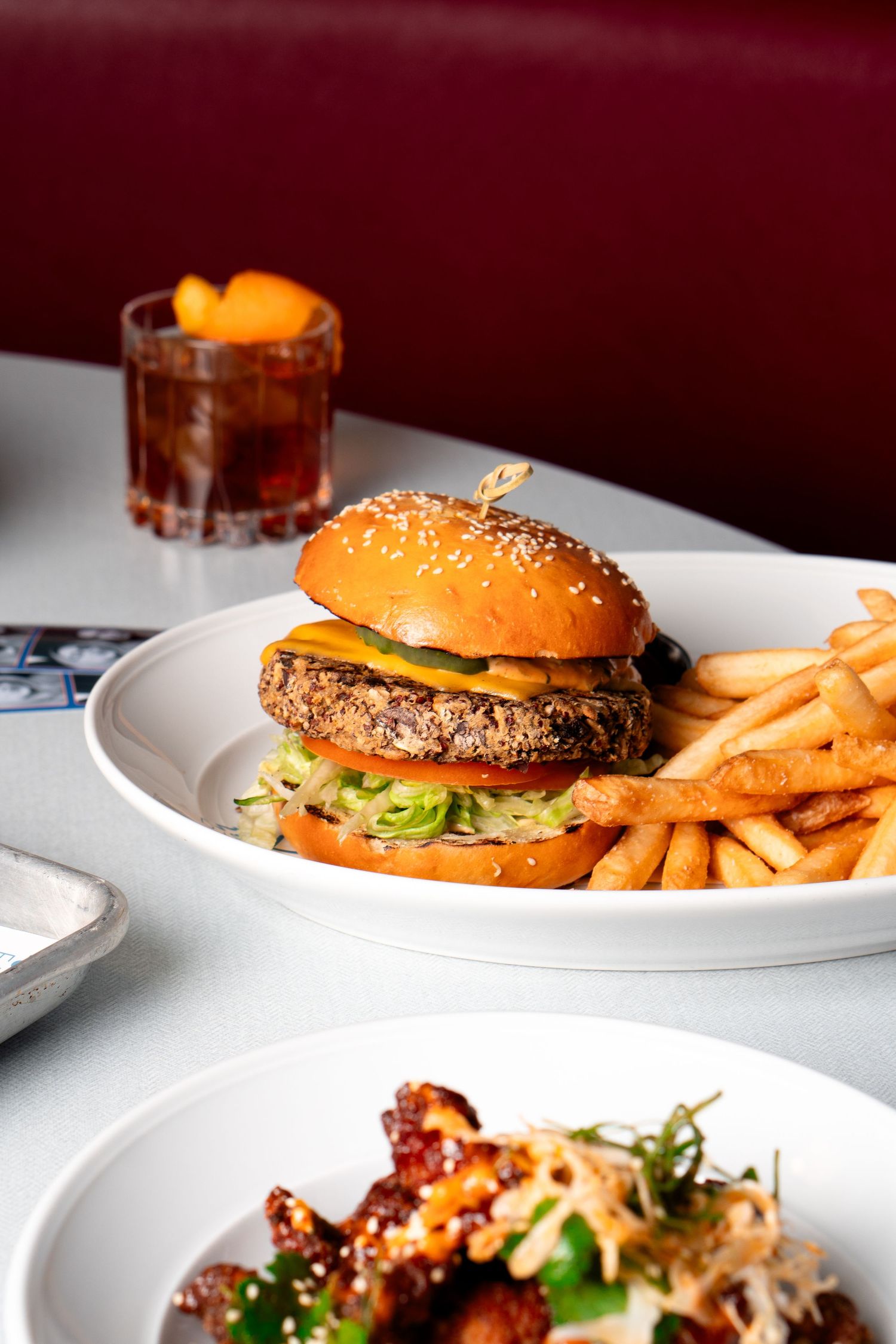 Gourmet cheeseburgers and appetizers served on white plates with golden french fries.