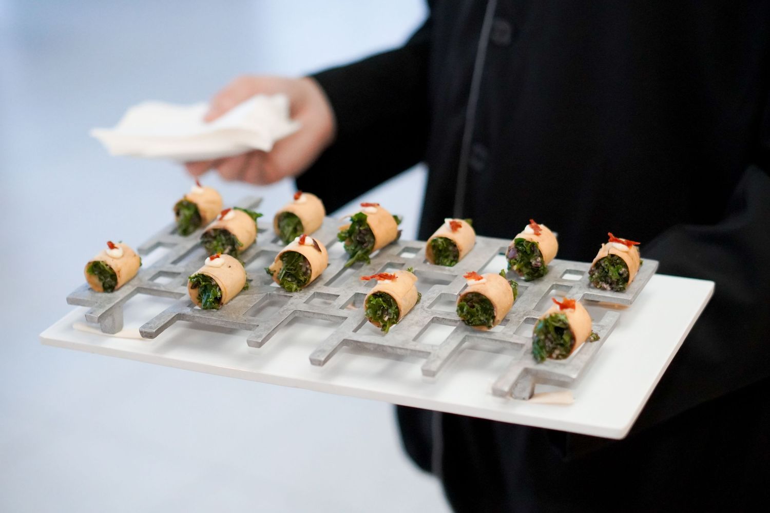 Catered appetizers elegantly plated on white serving dishes at professional event.