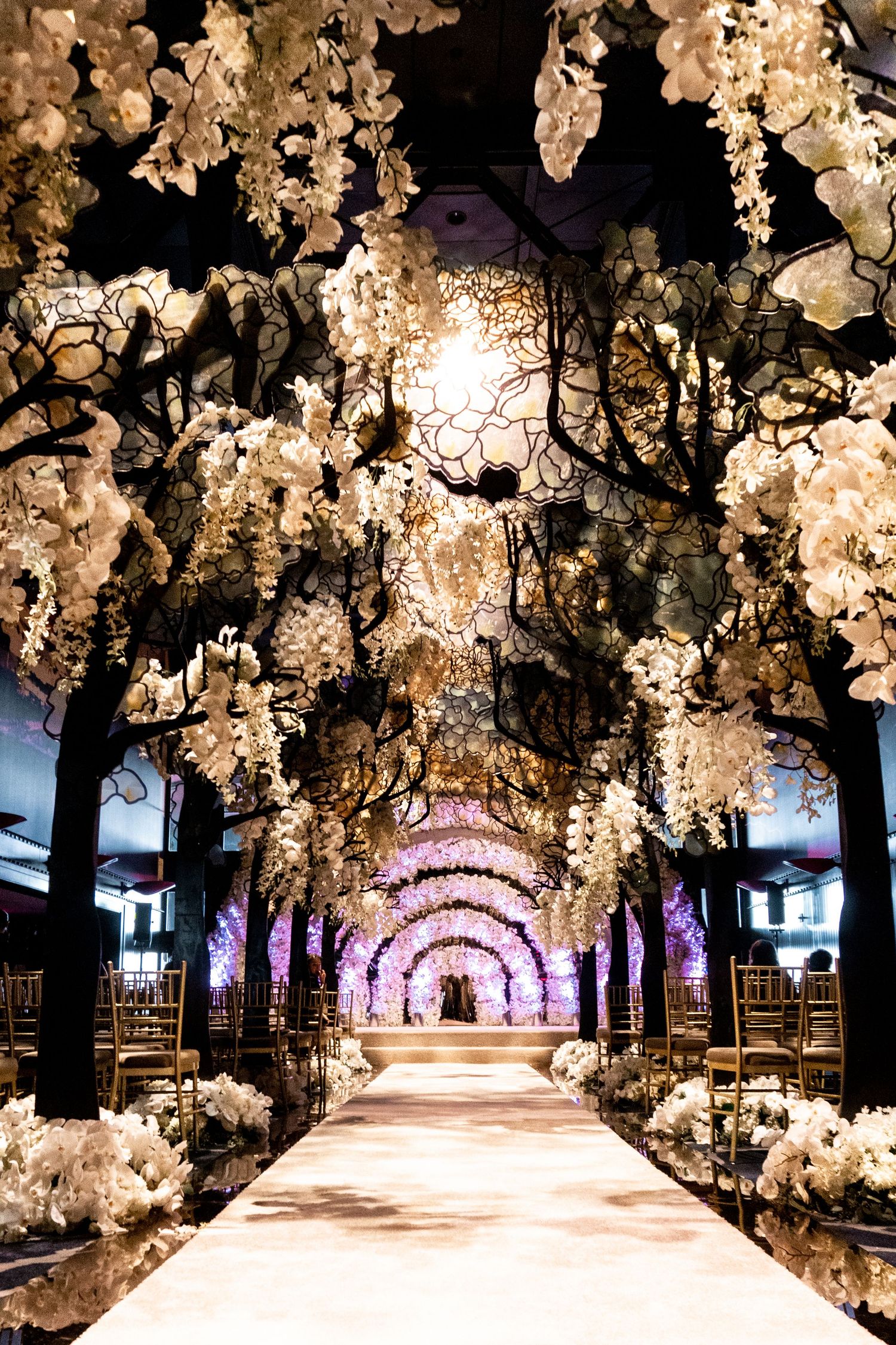 Stunning tunnel walkway covered in illuminated white floral installations.