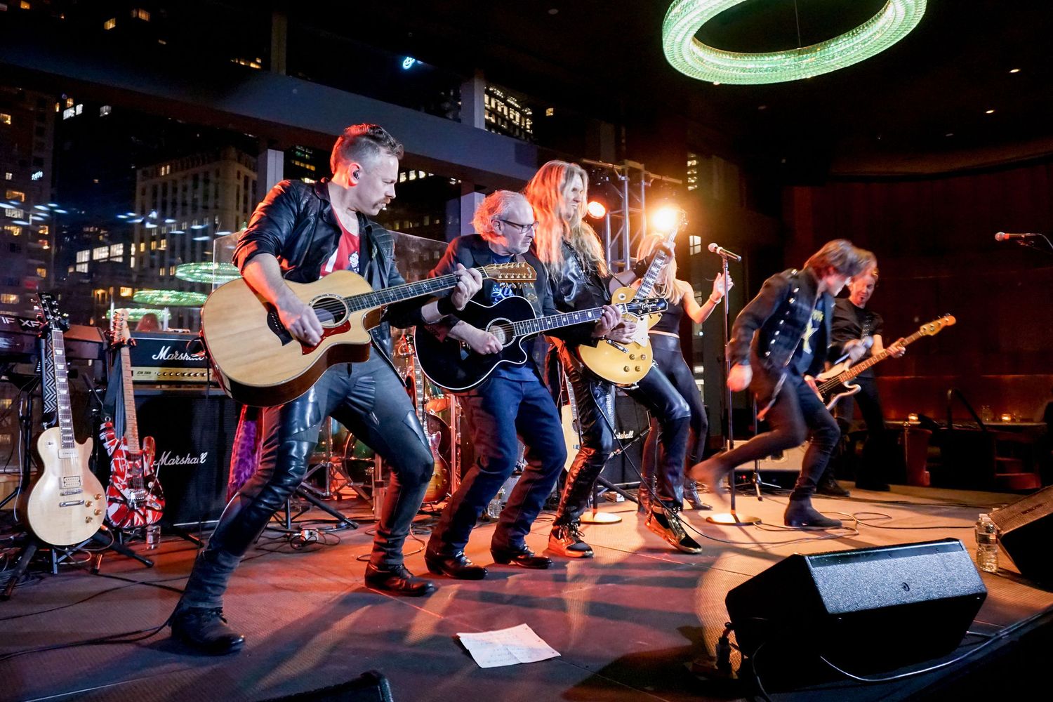 Rock band performing on stage with dramatic lighting effects.