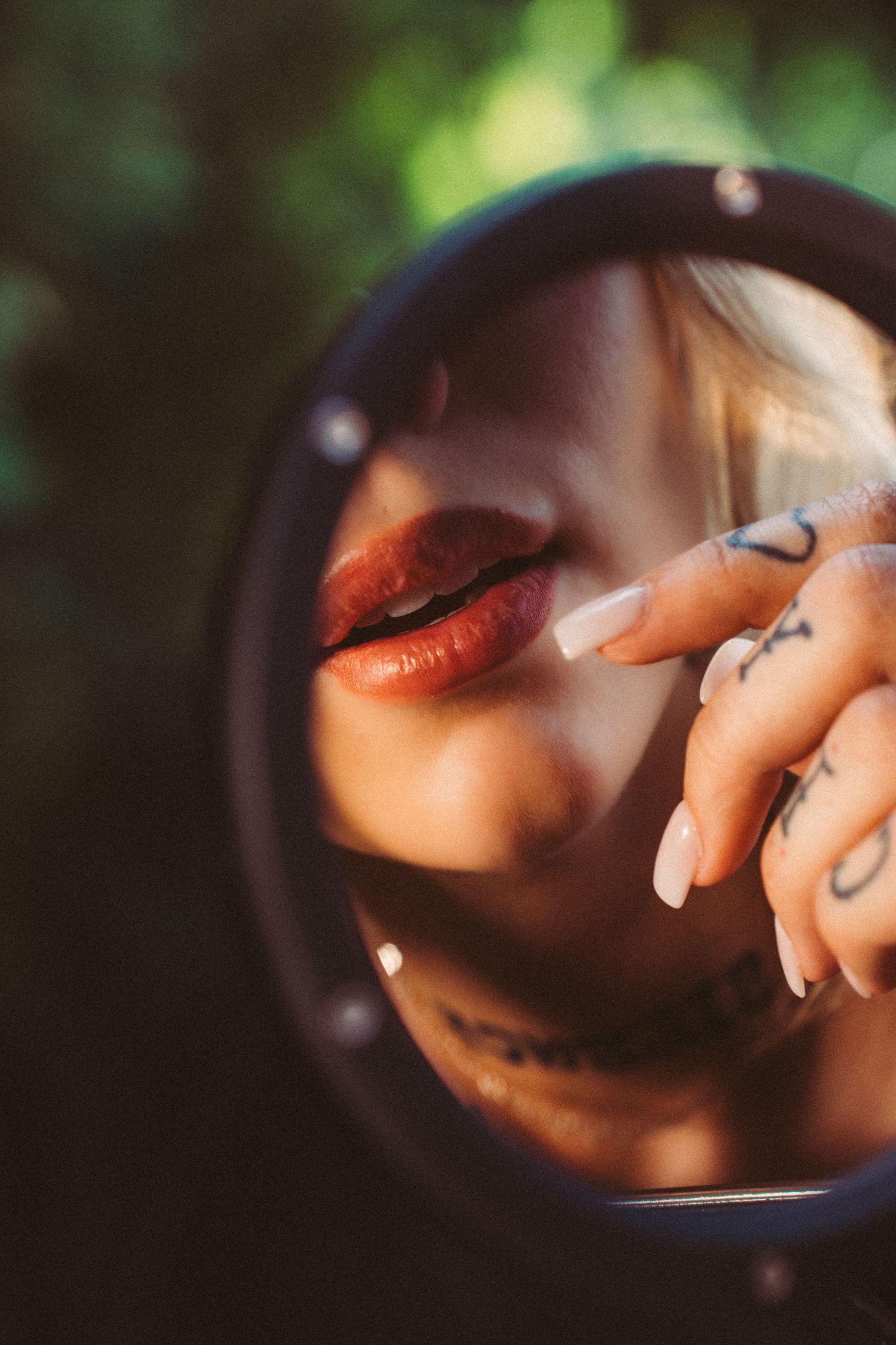 Close-up reflection in round mirror with warm lighting and artistic composition.