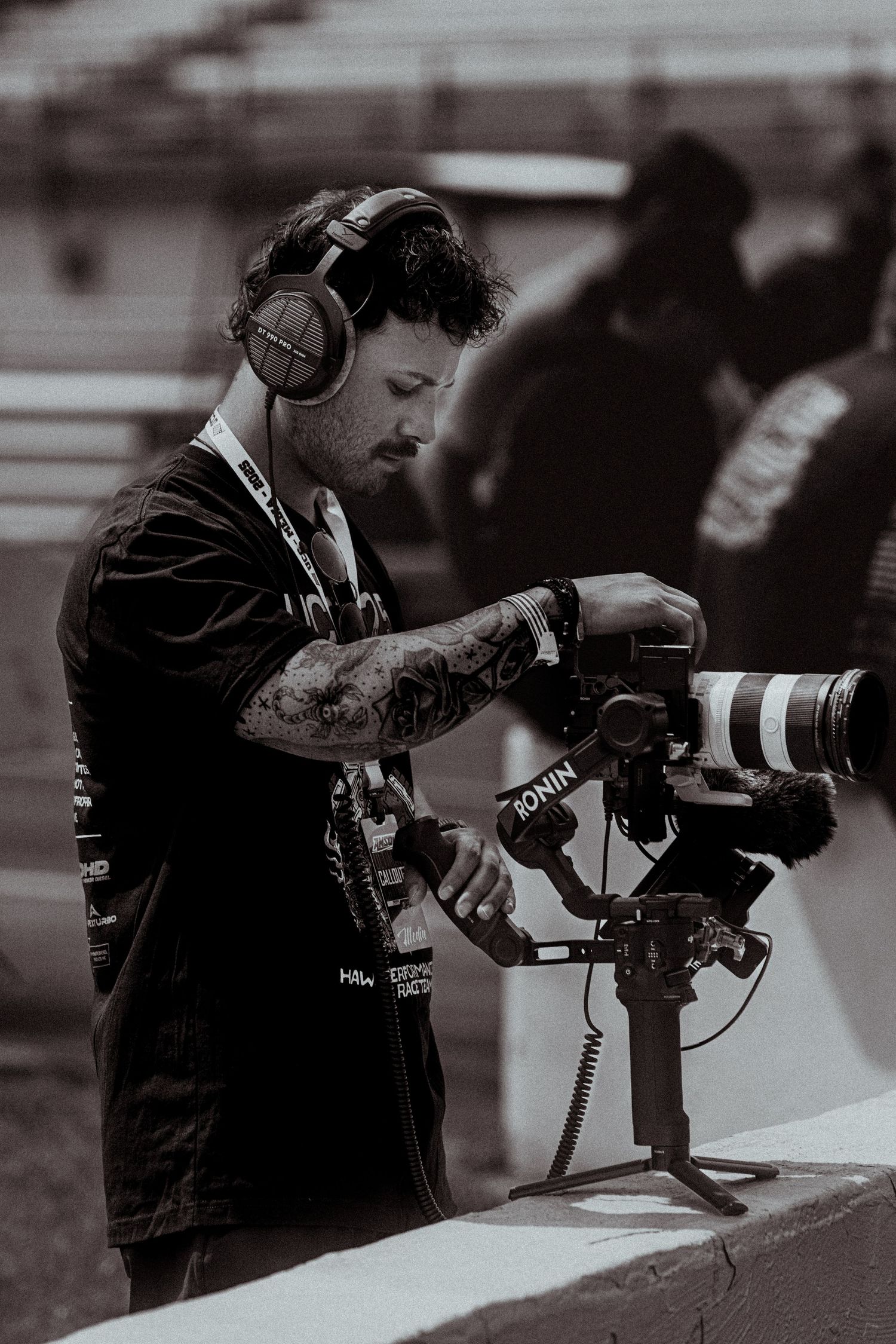Row of photographers with professional cameras shooting at an event in black and white.