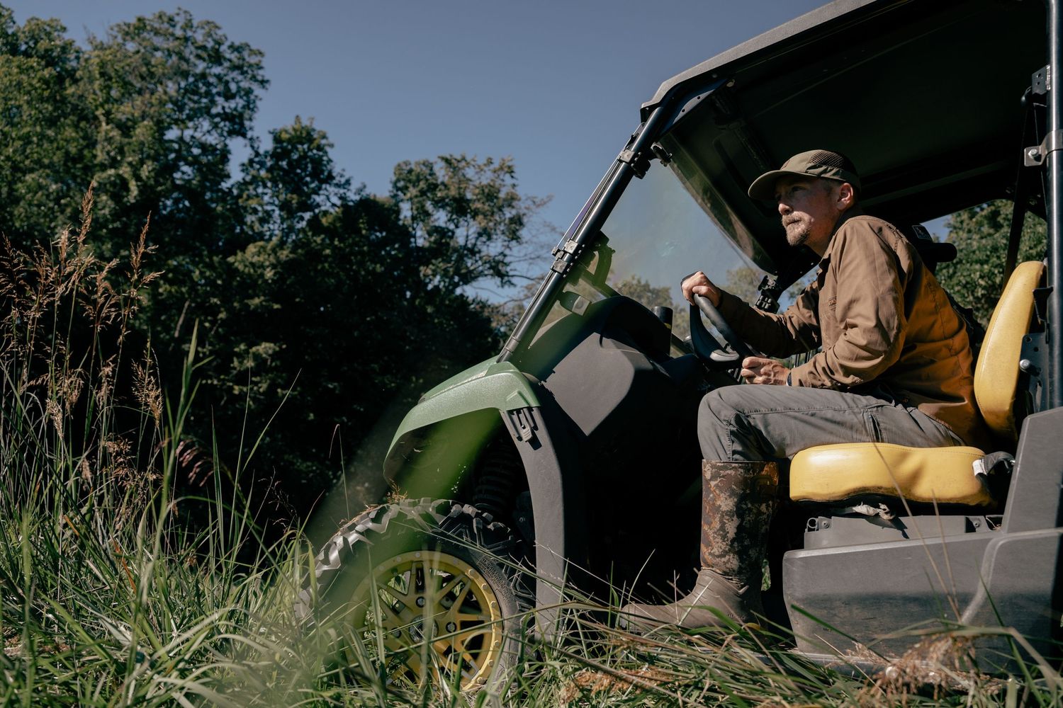 Duck hunters with gear preparing equipment in tall grass.