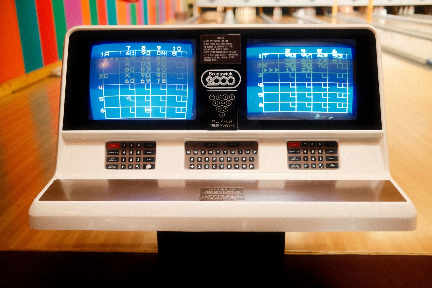 Multiple retro LCD displays showing blue grid patterns on wooden desk.