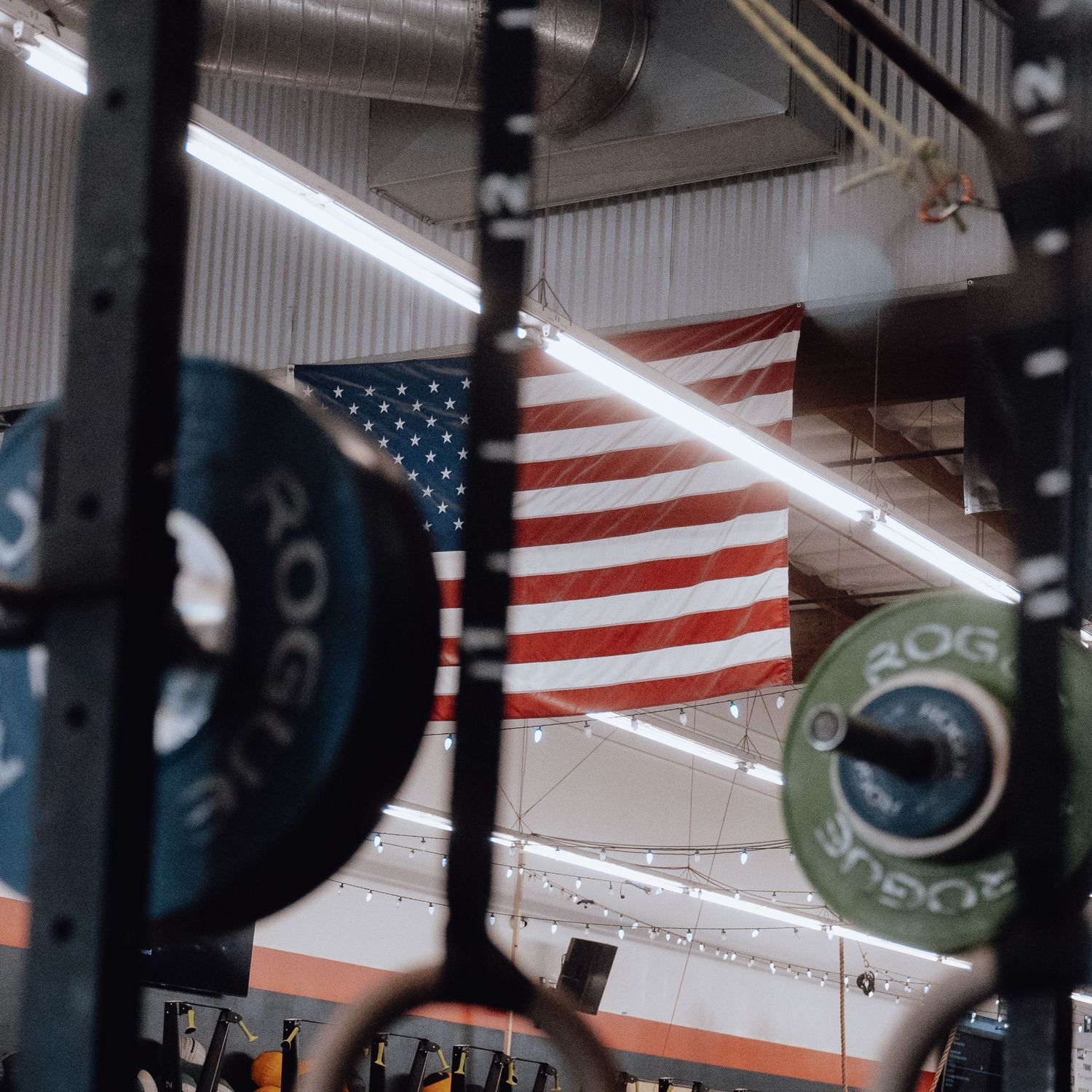 Fitness facility with American flags displayed and weightlifting equipment.