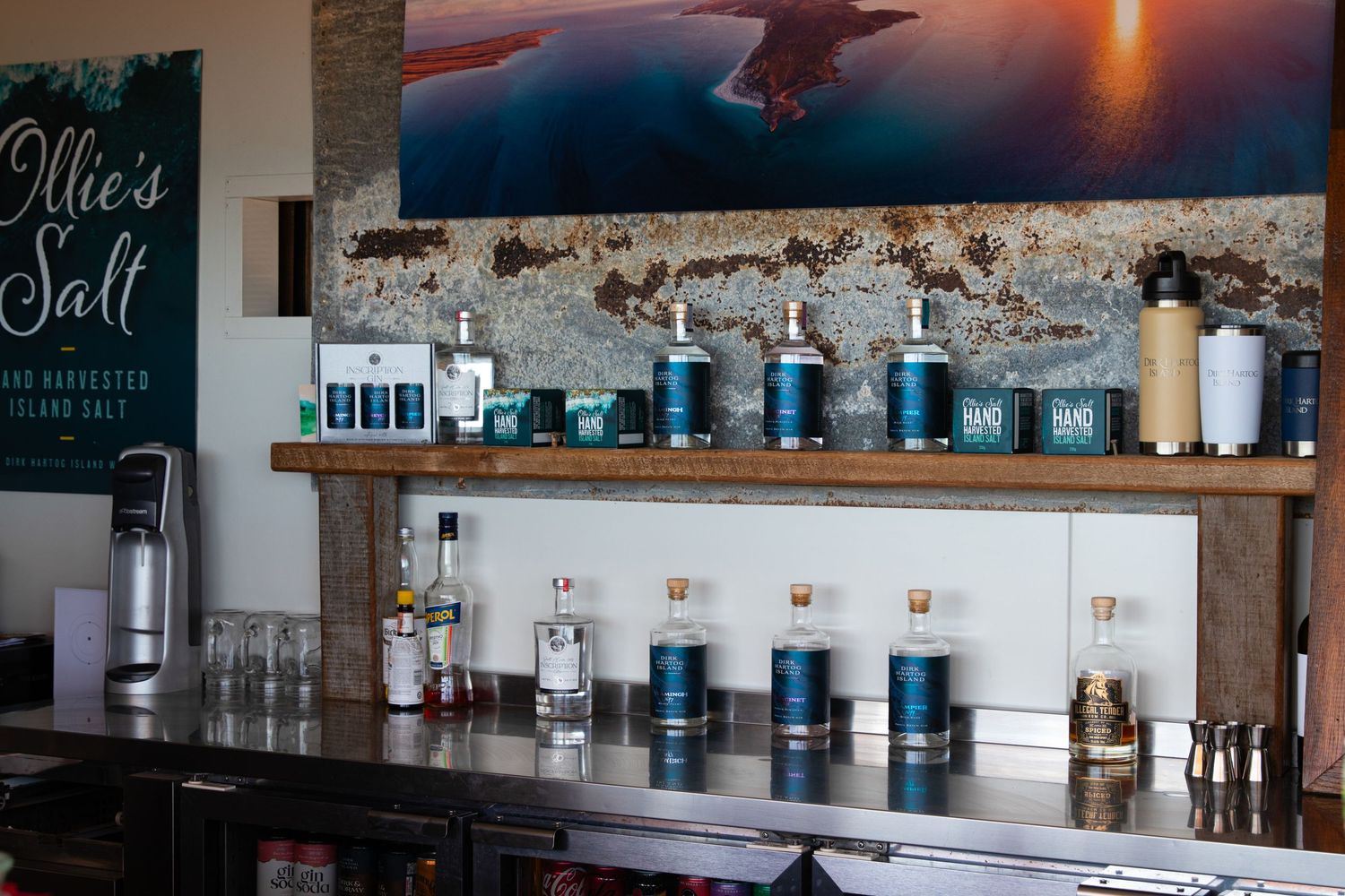 Ollie's Salt hand-harvested island salt products displayed on rustic wooden bar shelf in coastal tasting room.