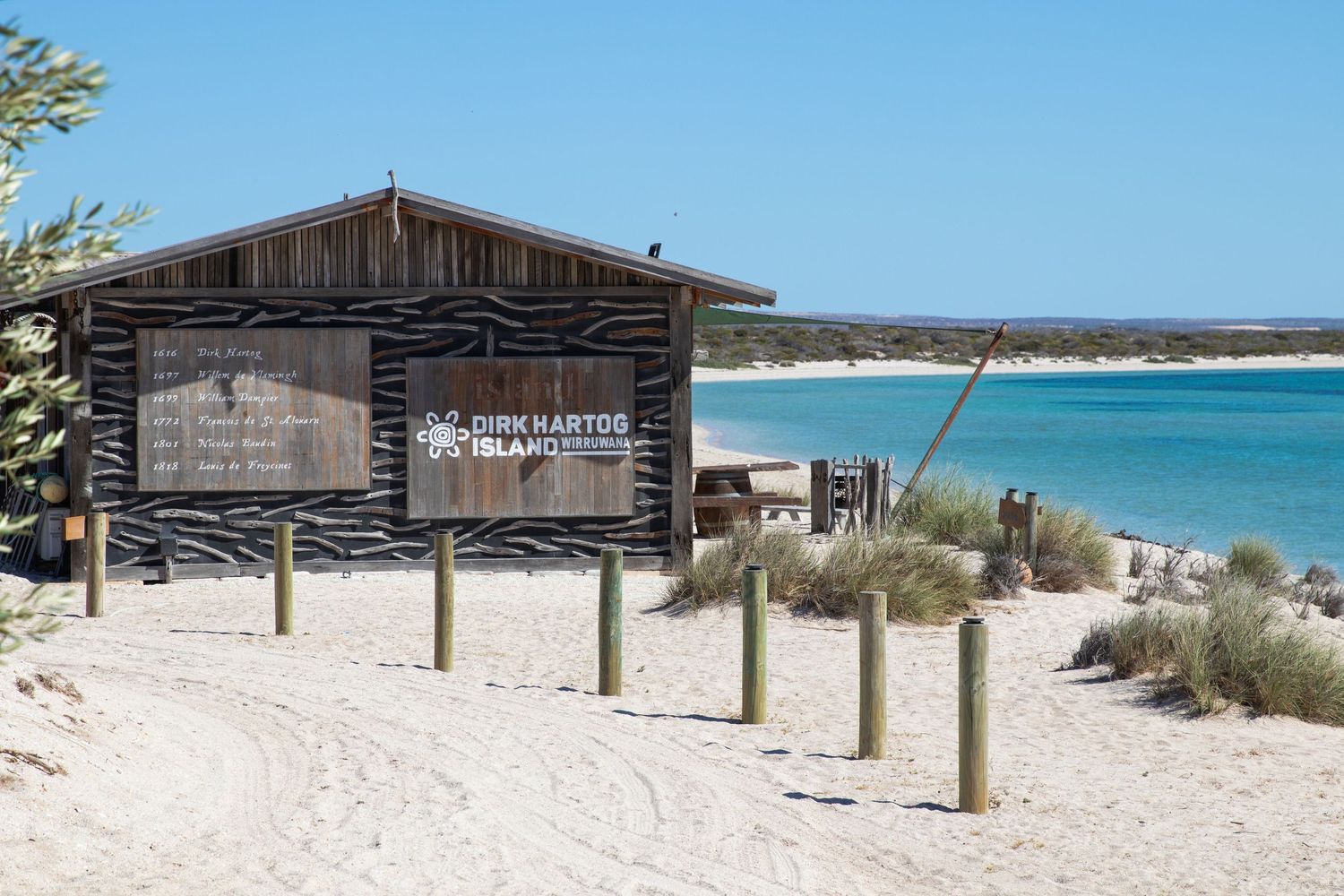 Dirk Hartog Island information sign at sandy beach entrance with stunning turquoise ocean views, WA.