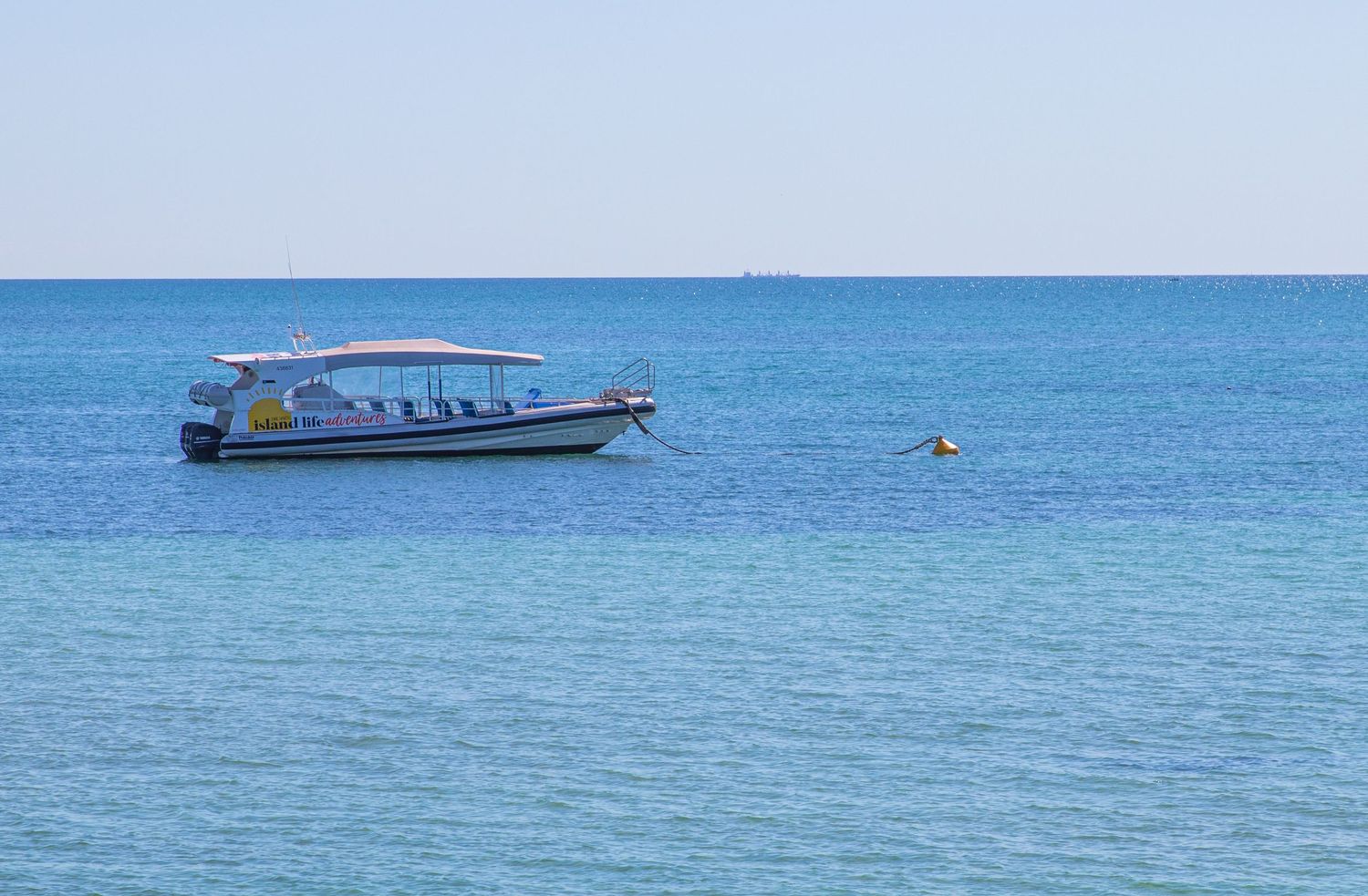 White tour boat floating on calm turquoise waters off Dirk Hartog Island, Western Australia.