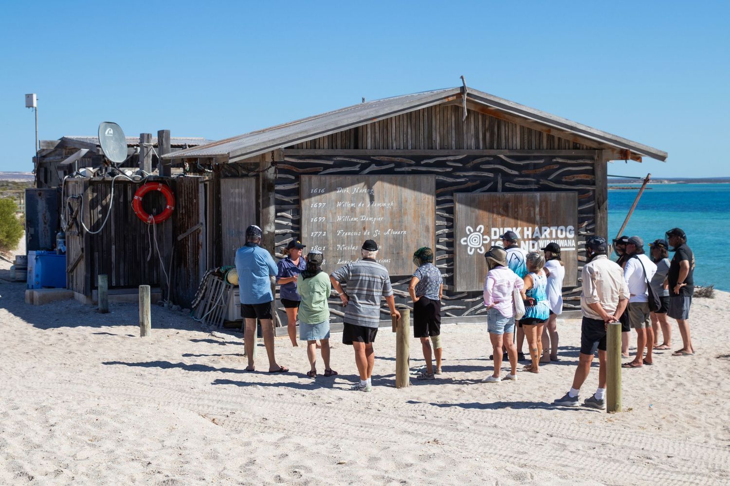 Tourists queuing outside rustic wooden beach shack at Dirk Hartog Island, Western Australia.