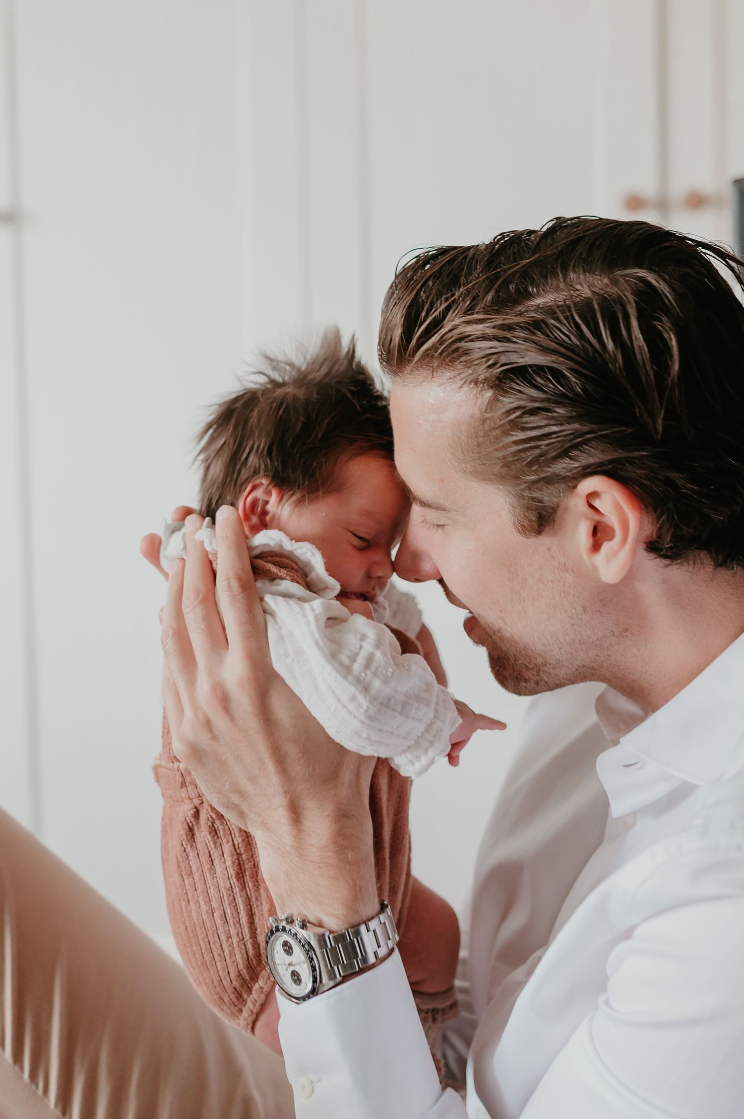 Papa houdt baby Alma vlak voor zijn gezicht, voorhoofd-aan-voorhoofd, newborn shoot Roeselare