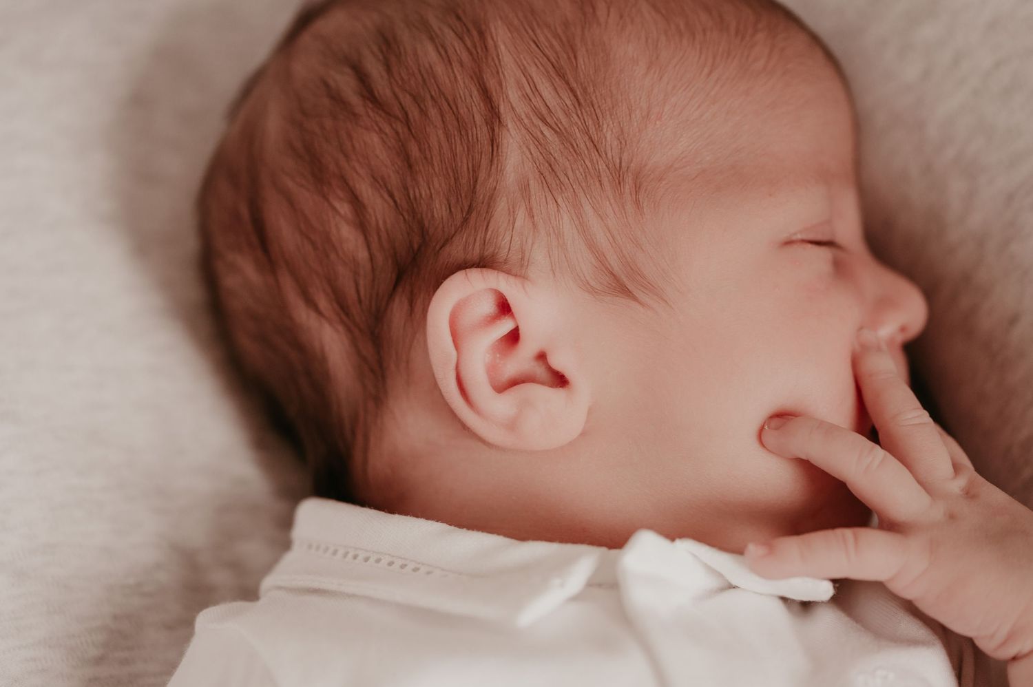 Close-up van slapende pasgeboren baby Omer met handje bij zijn wangetje, newborn fotografie Roeselare
