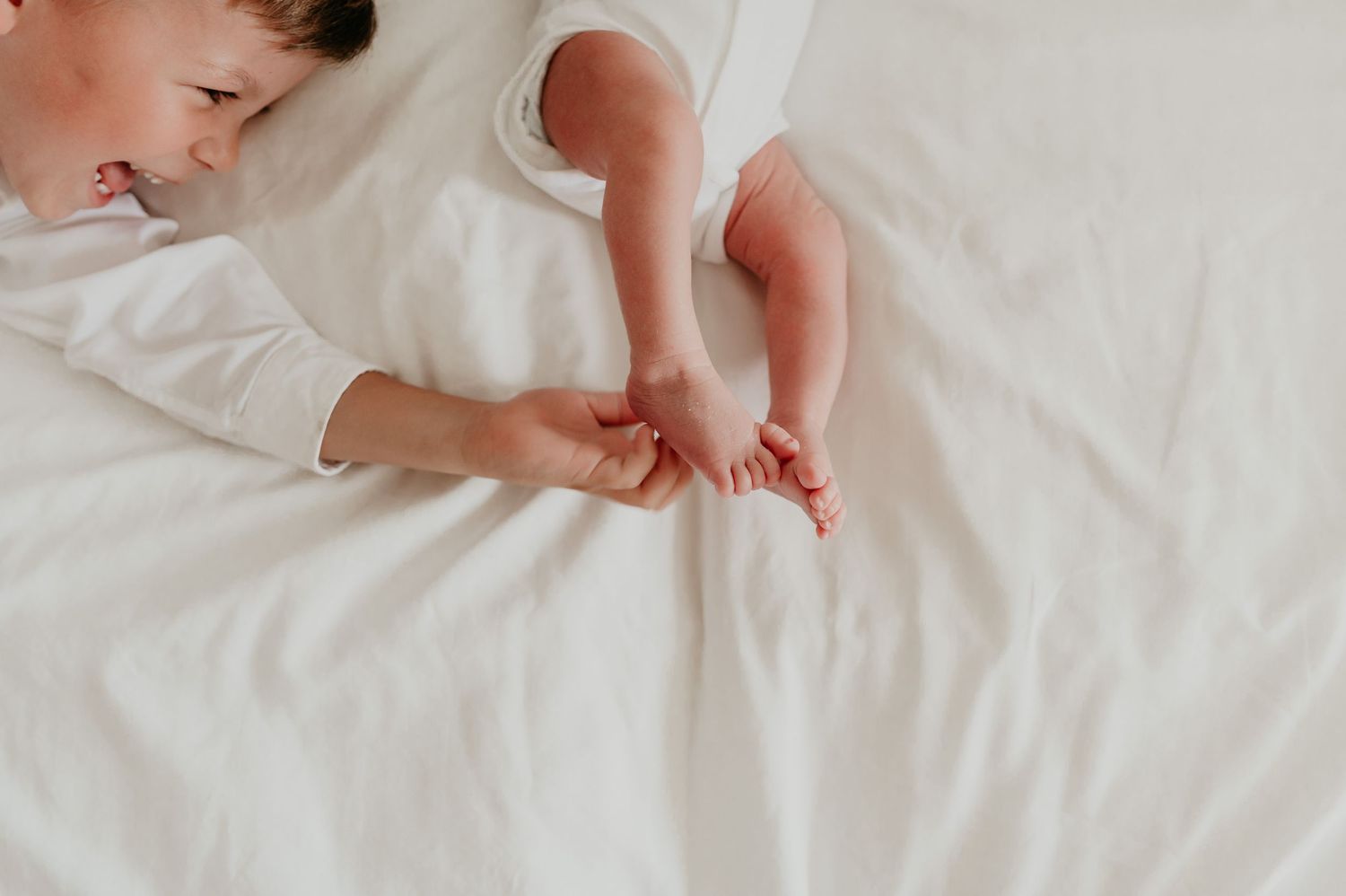 Pasgeboren baby rust vredig op witte zachte ondergrond, close-up newborn fotografie Roeselare