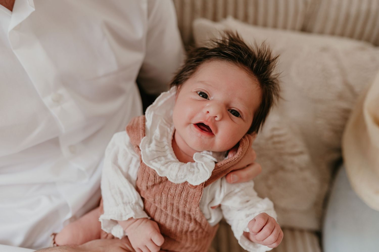 Baby Alma lacht breed op zachte ondergrond, blije newborn geboortereportage fotograaf Roeselare