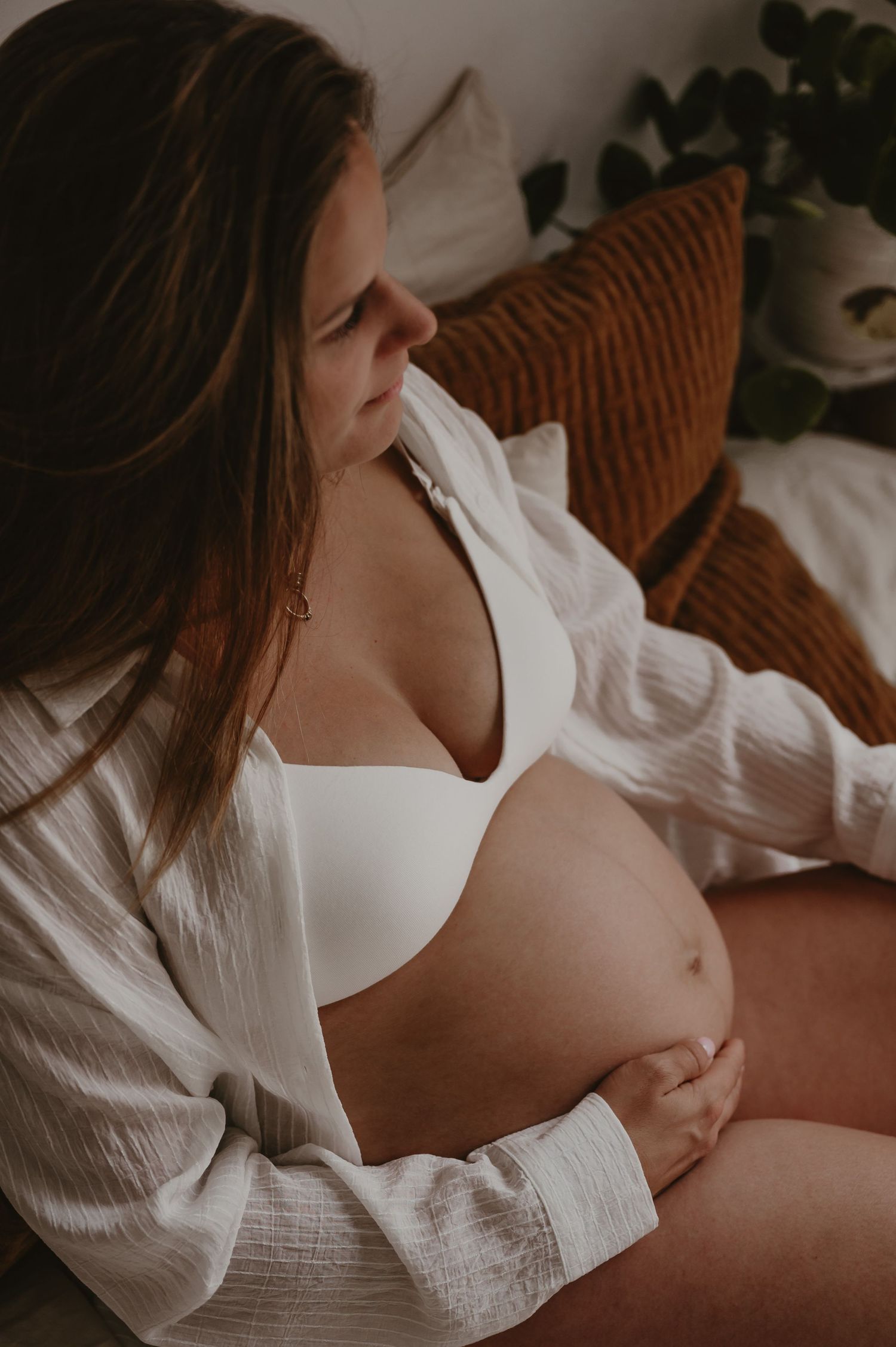 Zwangere vrouw in open wit overhemd toont ronde buik, lifestyle zwangerschapsfotografie Roeselare