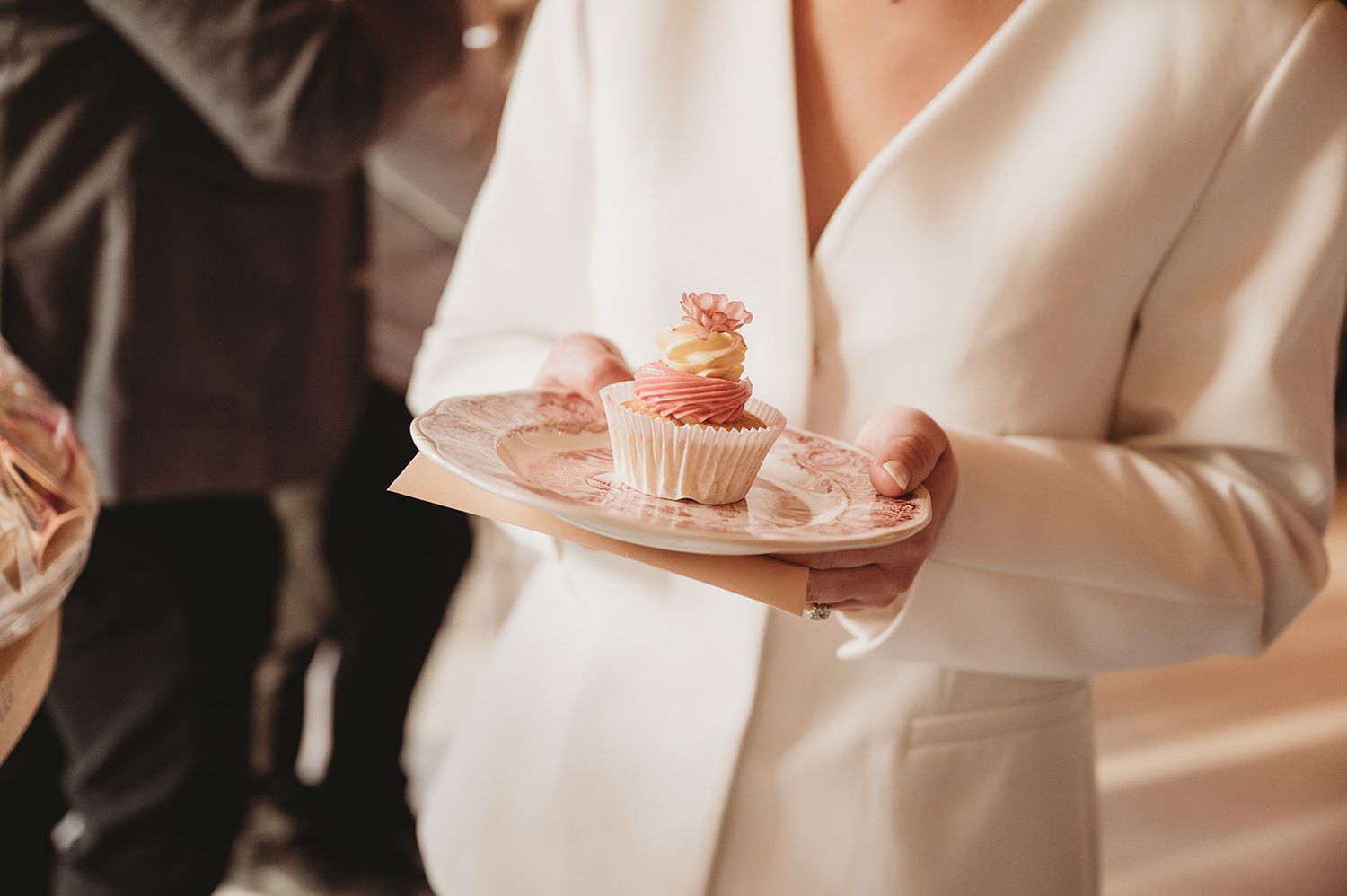 Detail van bruid met bordje mini-cupcakes op het trouwfeest — huwelijksfotograaf West-Vlaanderen