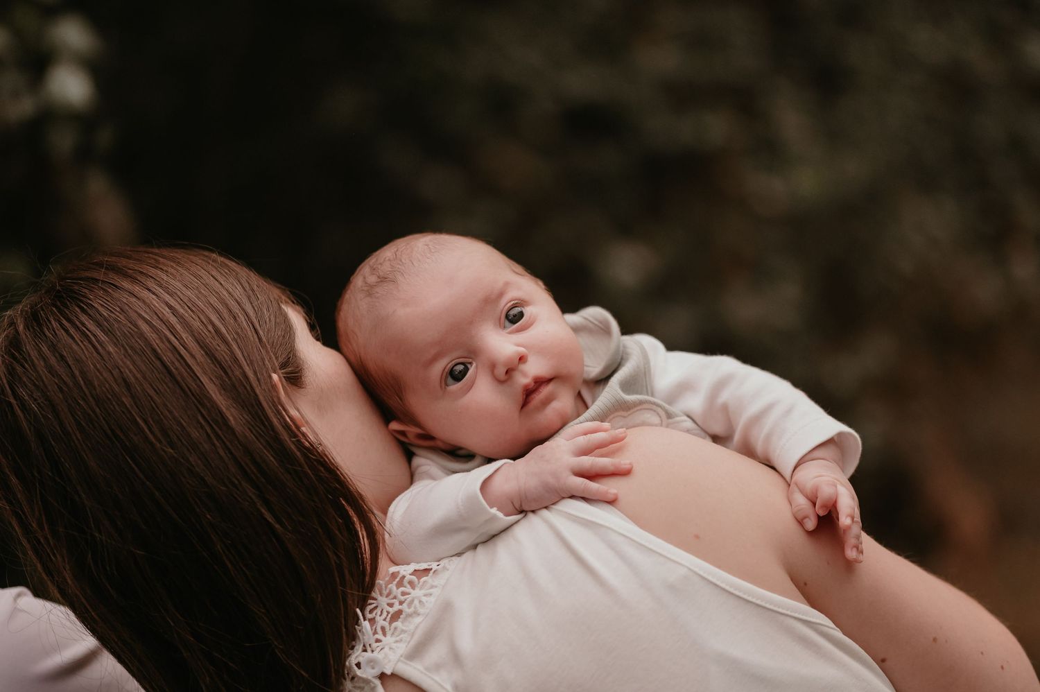Mama geeft een kus op de wang van haar pasgeboren baby, tweeling newborn shoot fotograaf Roeselare