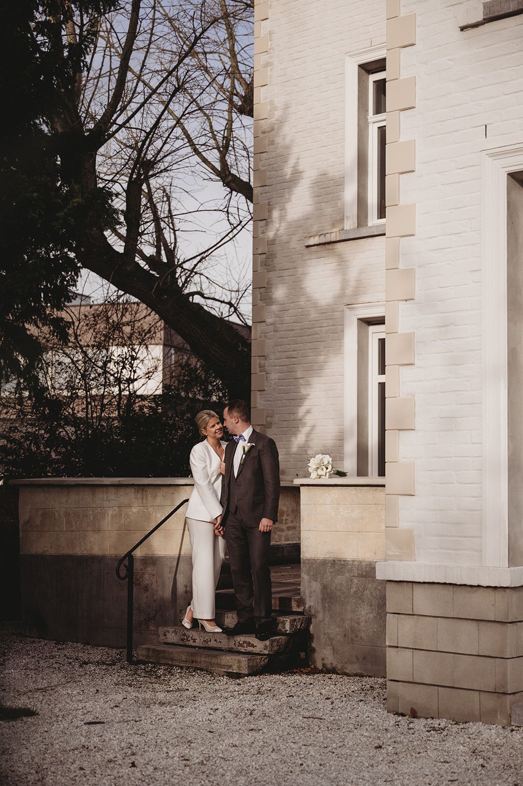Koppelportret tegen historische gevel in Brugge, huwelijksfotograaf West-Vlaanderen
