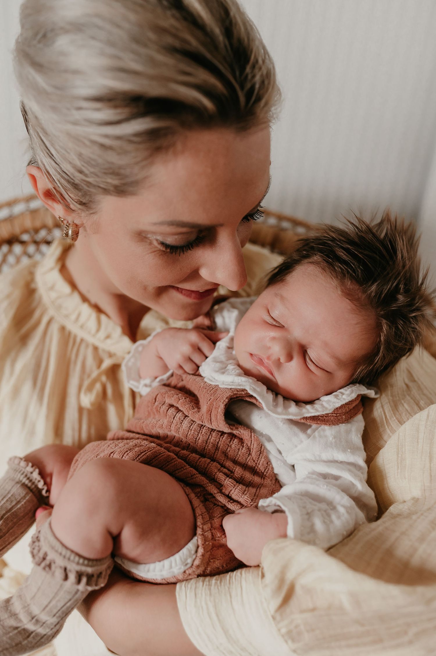 Mama houdt slapende baby Alma liefdevol in haar armen, lifestyle geboortereportage fotograaf Roeselare