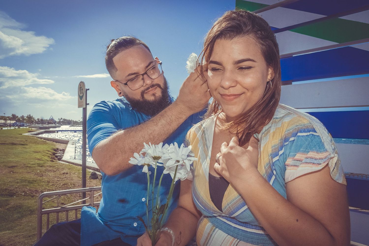 Couple sharing a tender outdoor moment at a fairground setting.