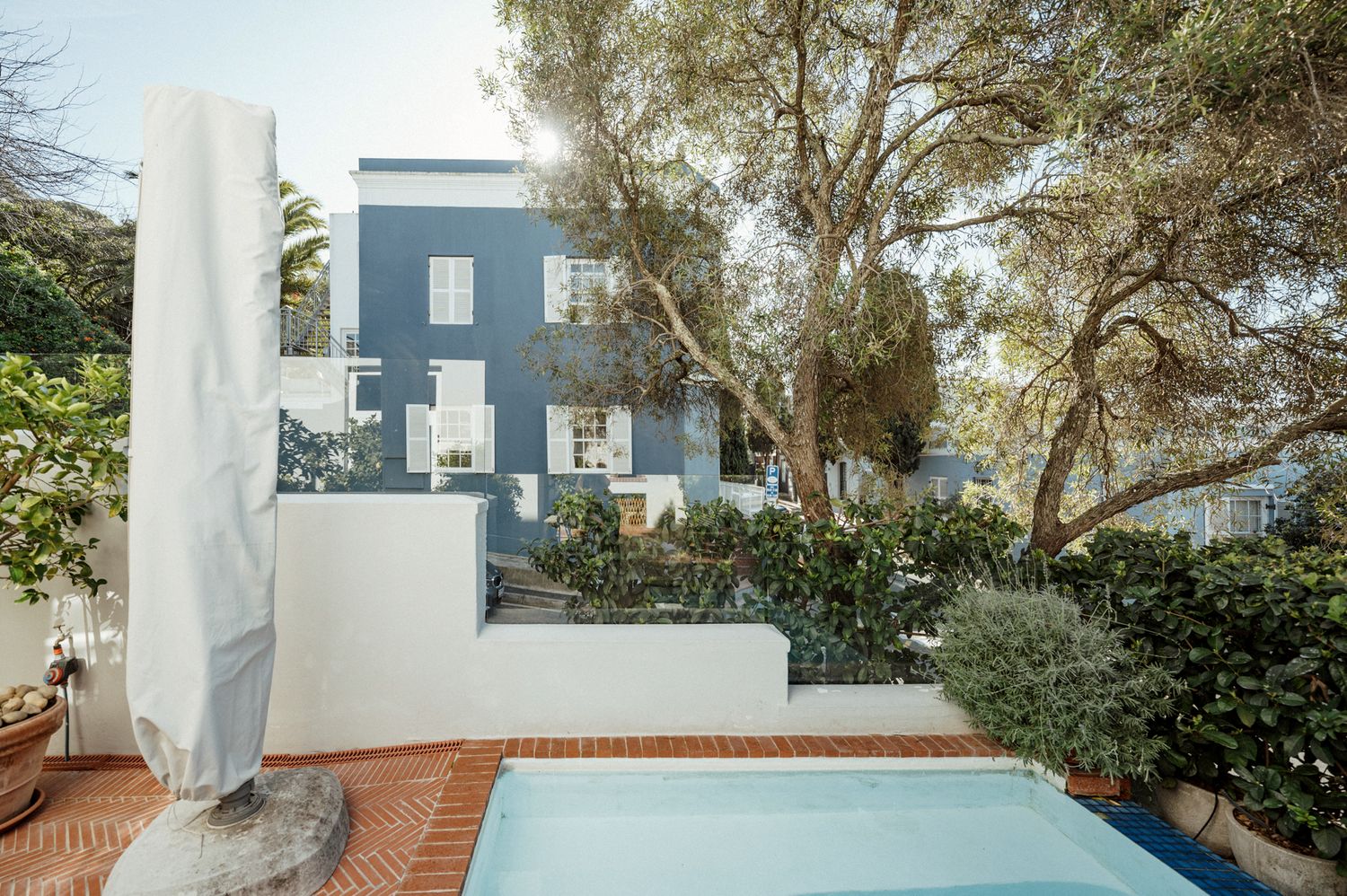 A collage of five exterior property views showing a pool, terrace, and modern architectural details in a coastal setting.