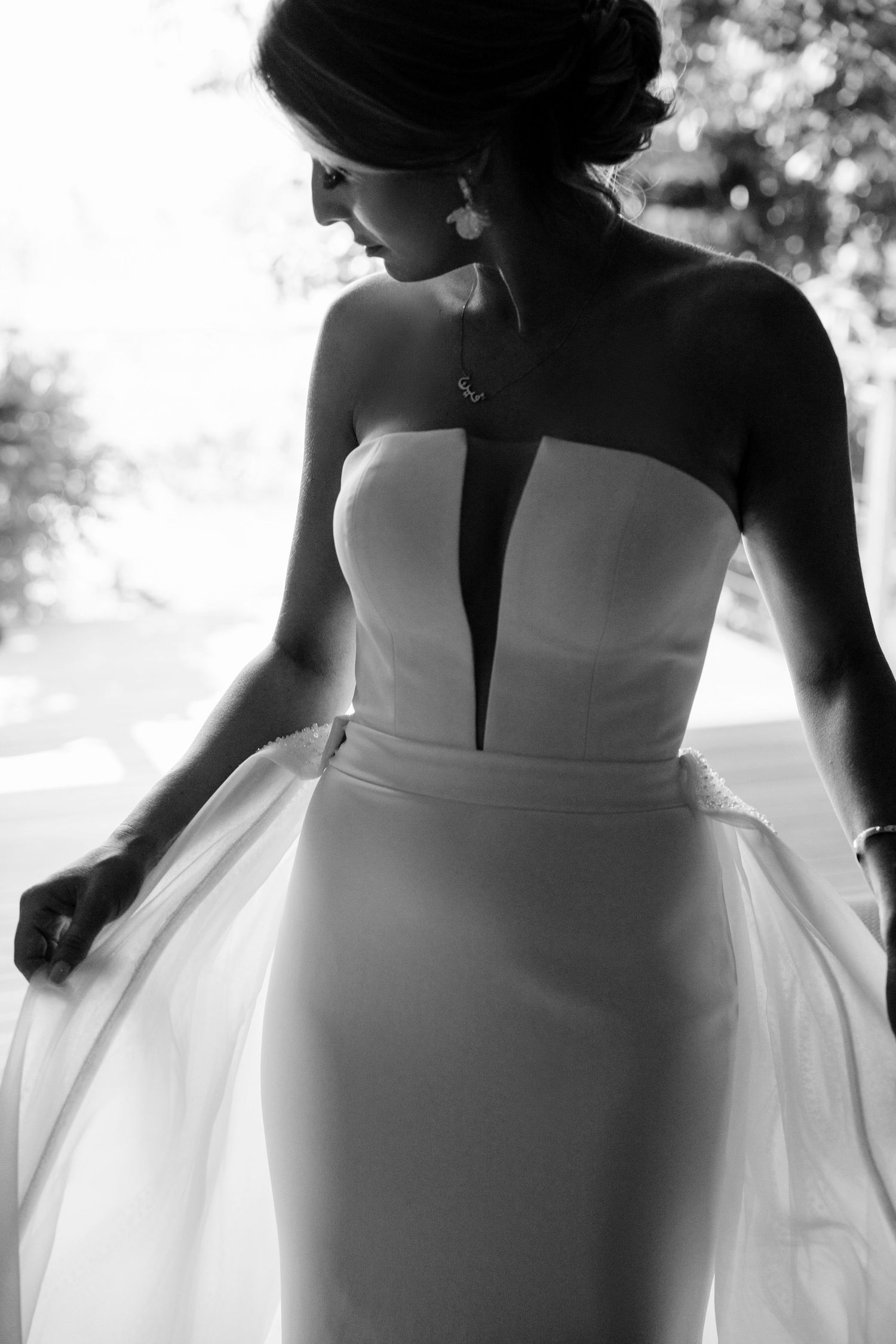 Elegant black and white silhouette of bride in strapless wedding dress with plunging neckline detail.