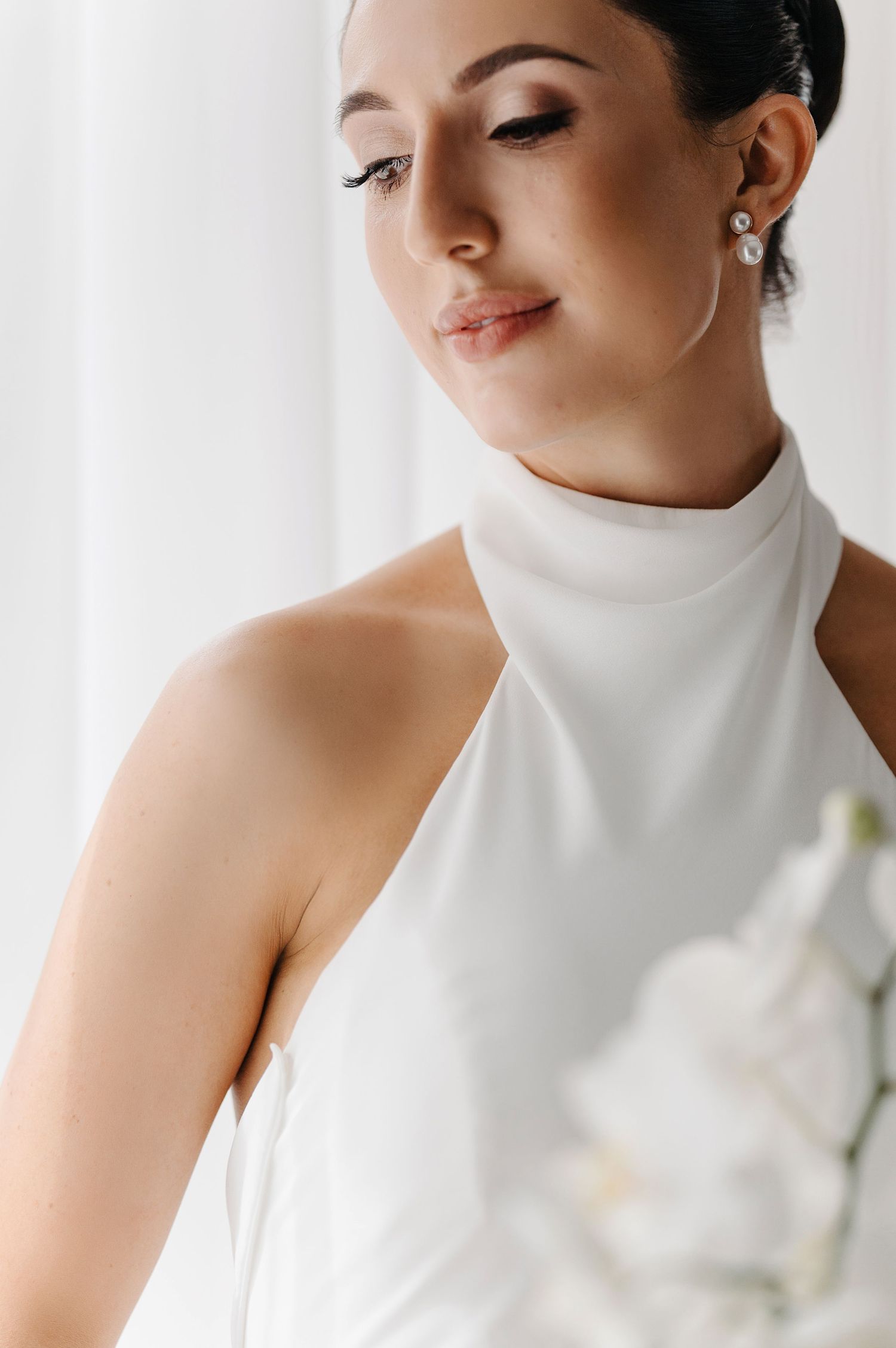 Elegant bridal portrait series showing close-up details of a high-neck white wedding dress and delicate pearl earring.