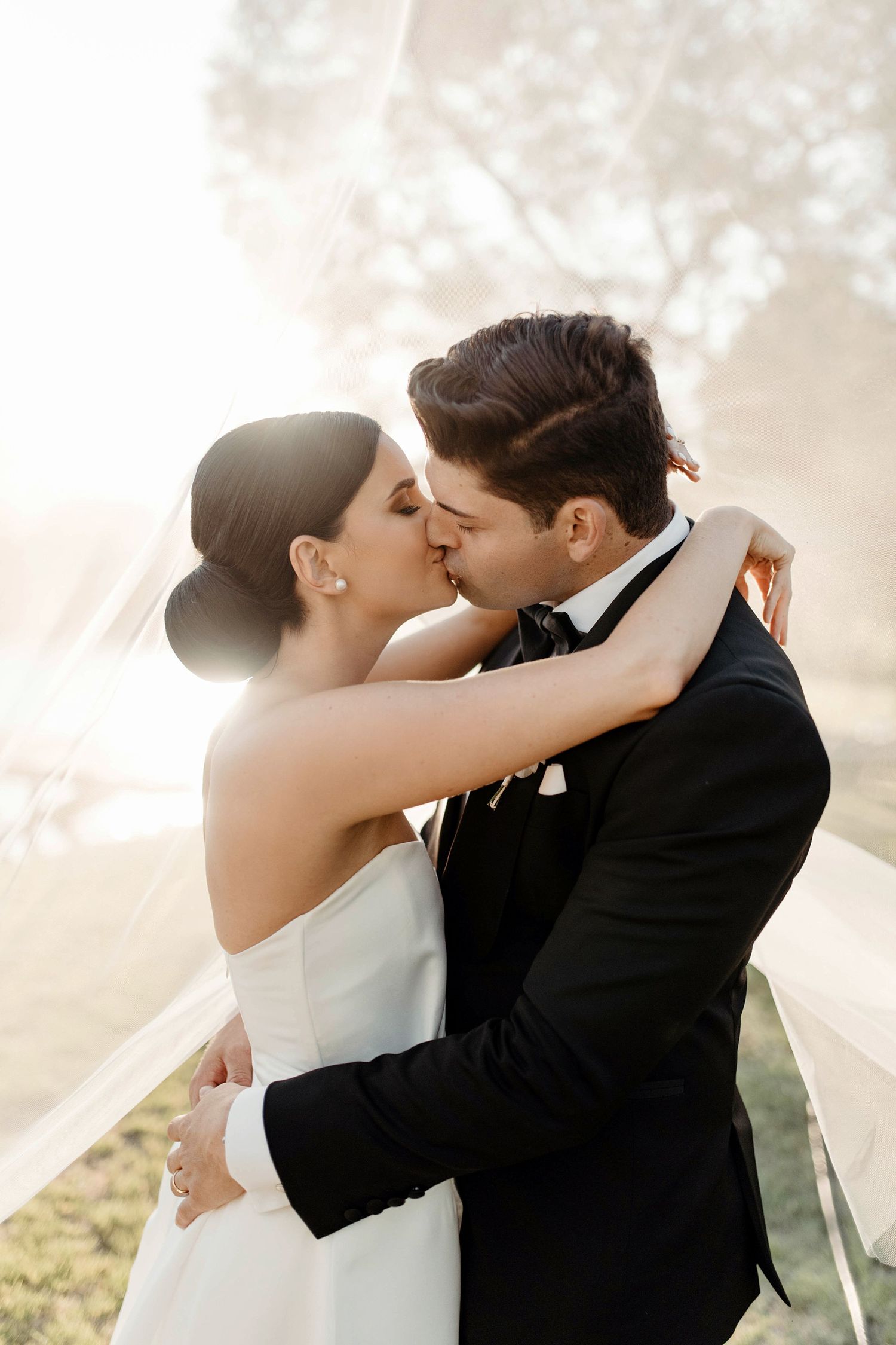 A romantic series of wedding photos showing a couple in formal attire sharing kisses at sunset.
