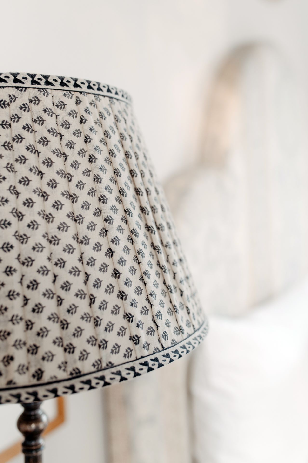 Close-up view of a patterned fabric lampshade with small floral motifs in black and white against a light background.