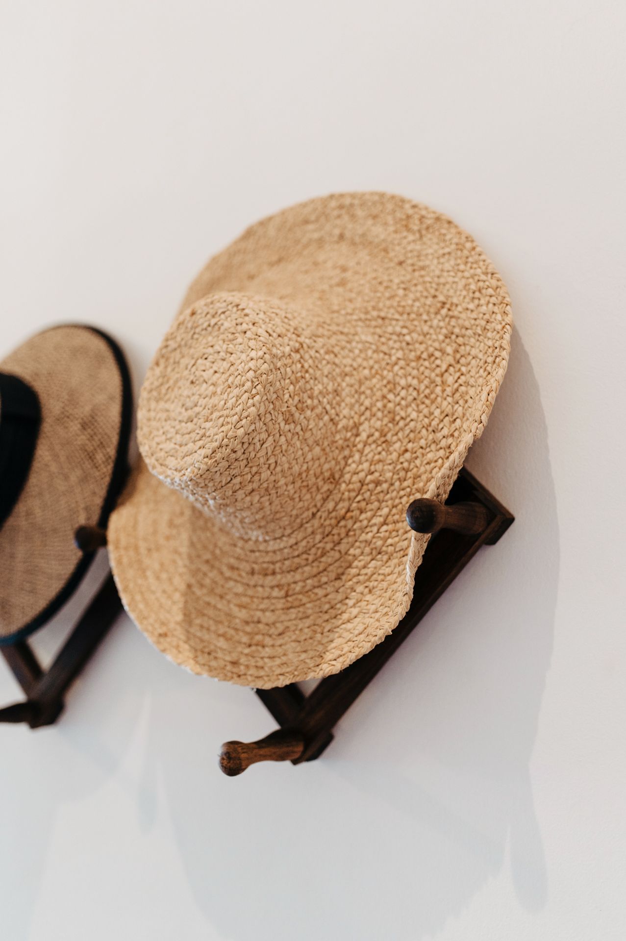 A sequence showing a woven straw hat gradually disappearing from view against a white background.