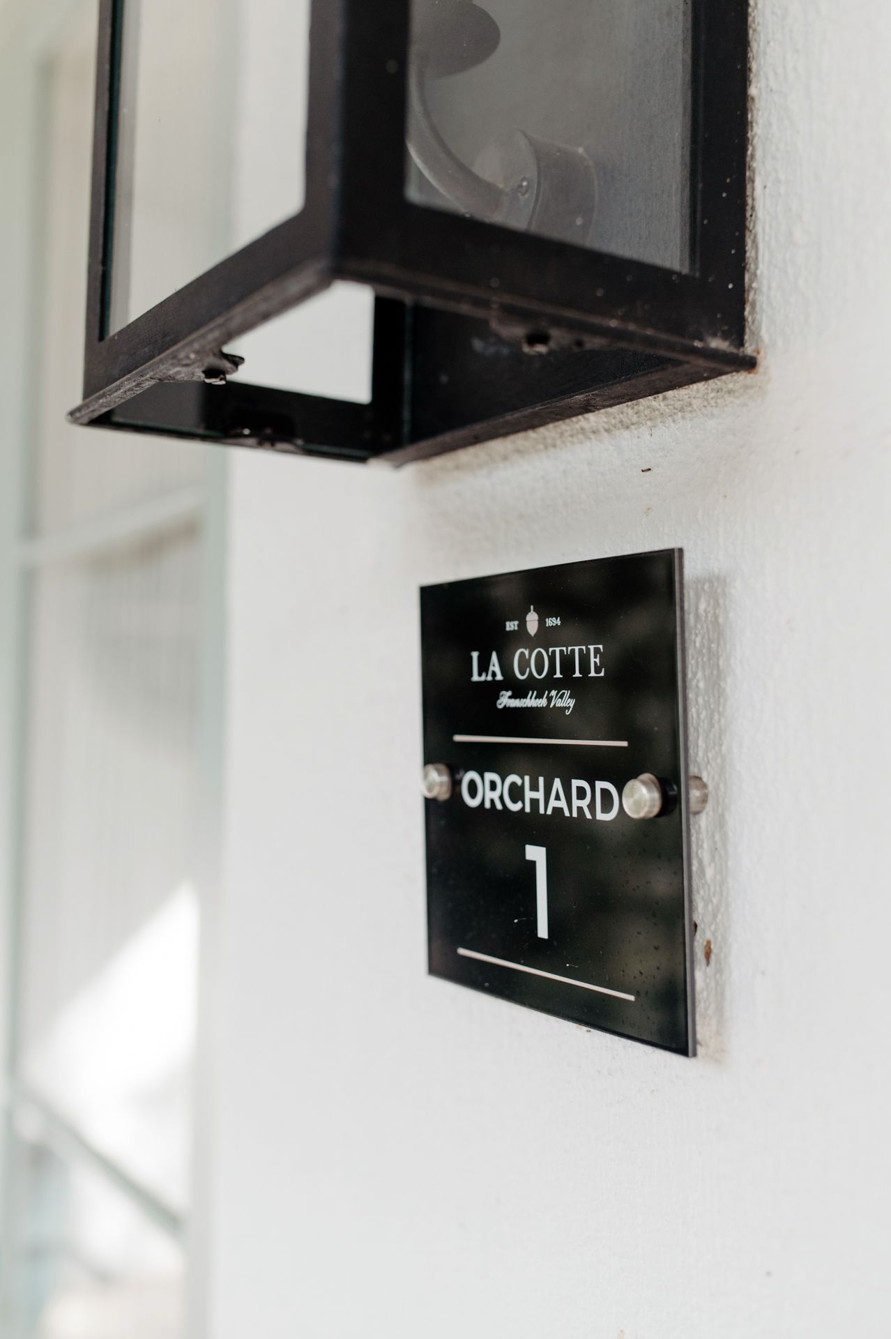 Black and white signage on a white wall showing text 'ORCHARD' and other directional information.