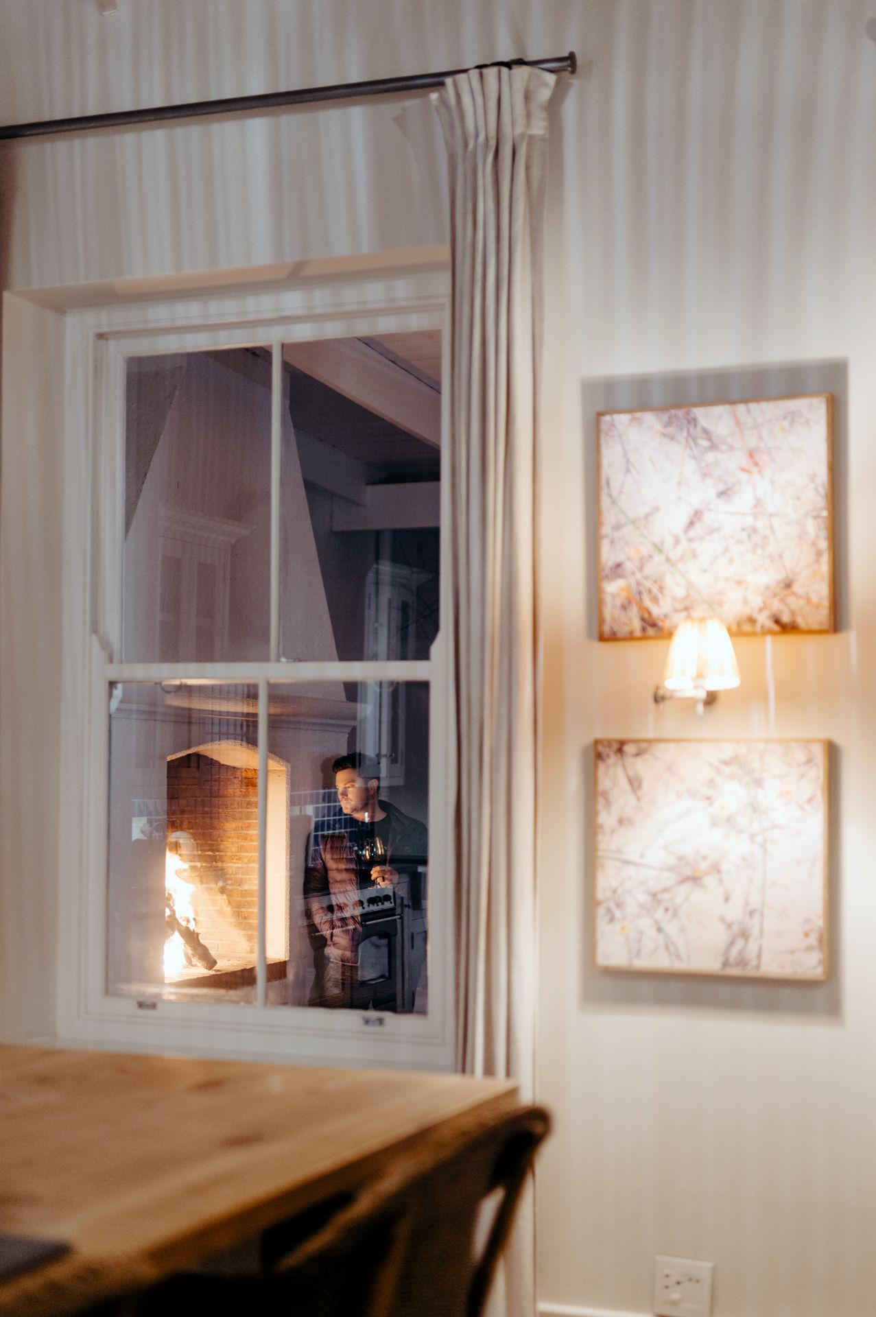 A sequence of photos showing a lamp illuminating a window at night, creating a warm glow against artwork on the wall.