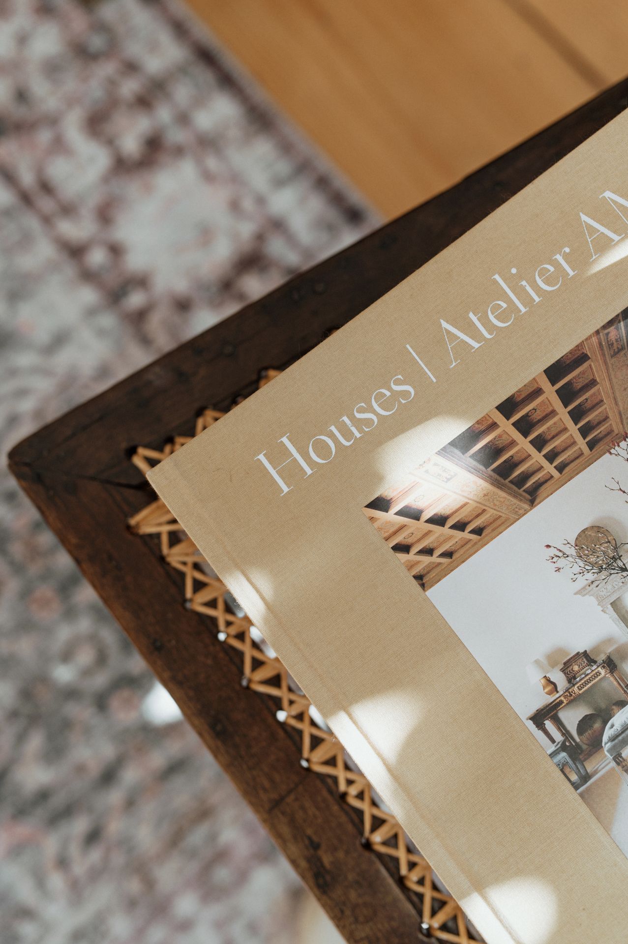 Close-up view of a photo album corner with brown leather binding and gold text details on beige pages.