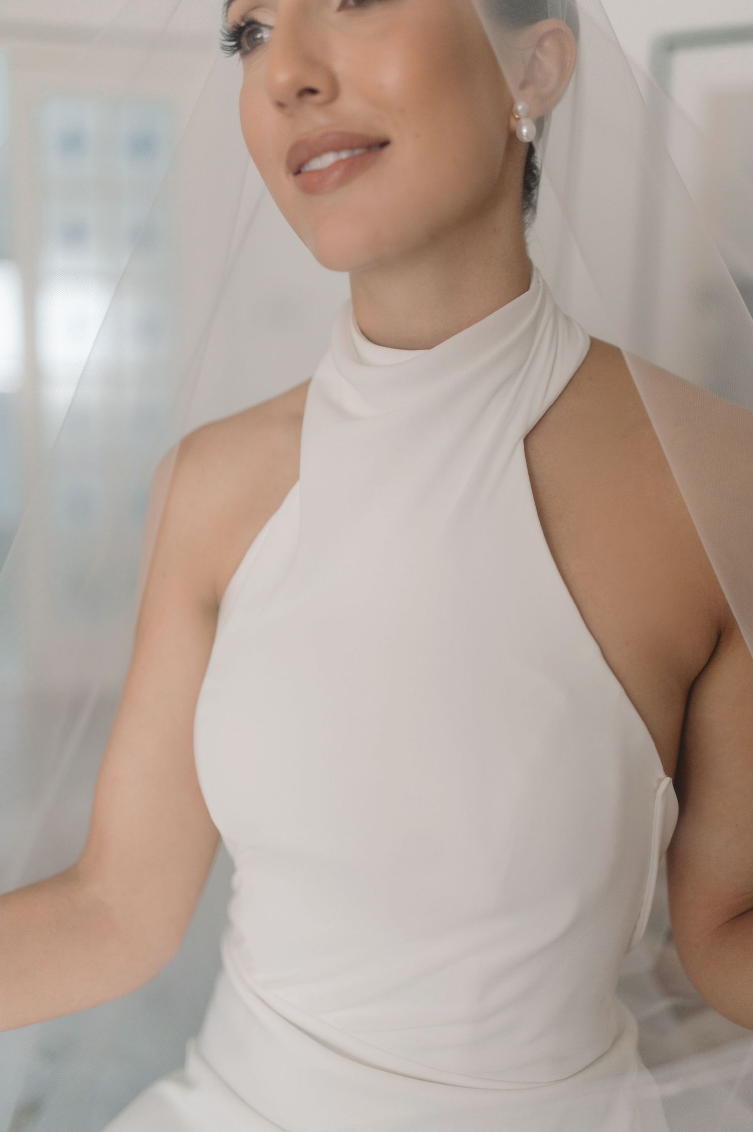 A series of fashion photos showing a sleeveless white high-neck top in different poses against a light background.