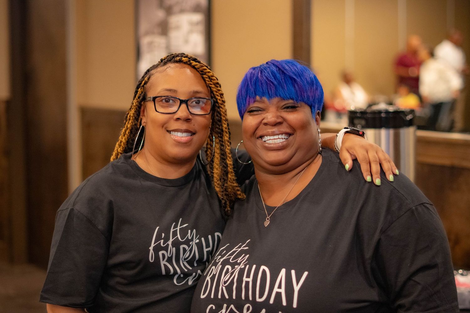 Birthday celebration with matching t-shirts and warm embraces in casual setting.