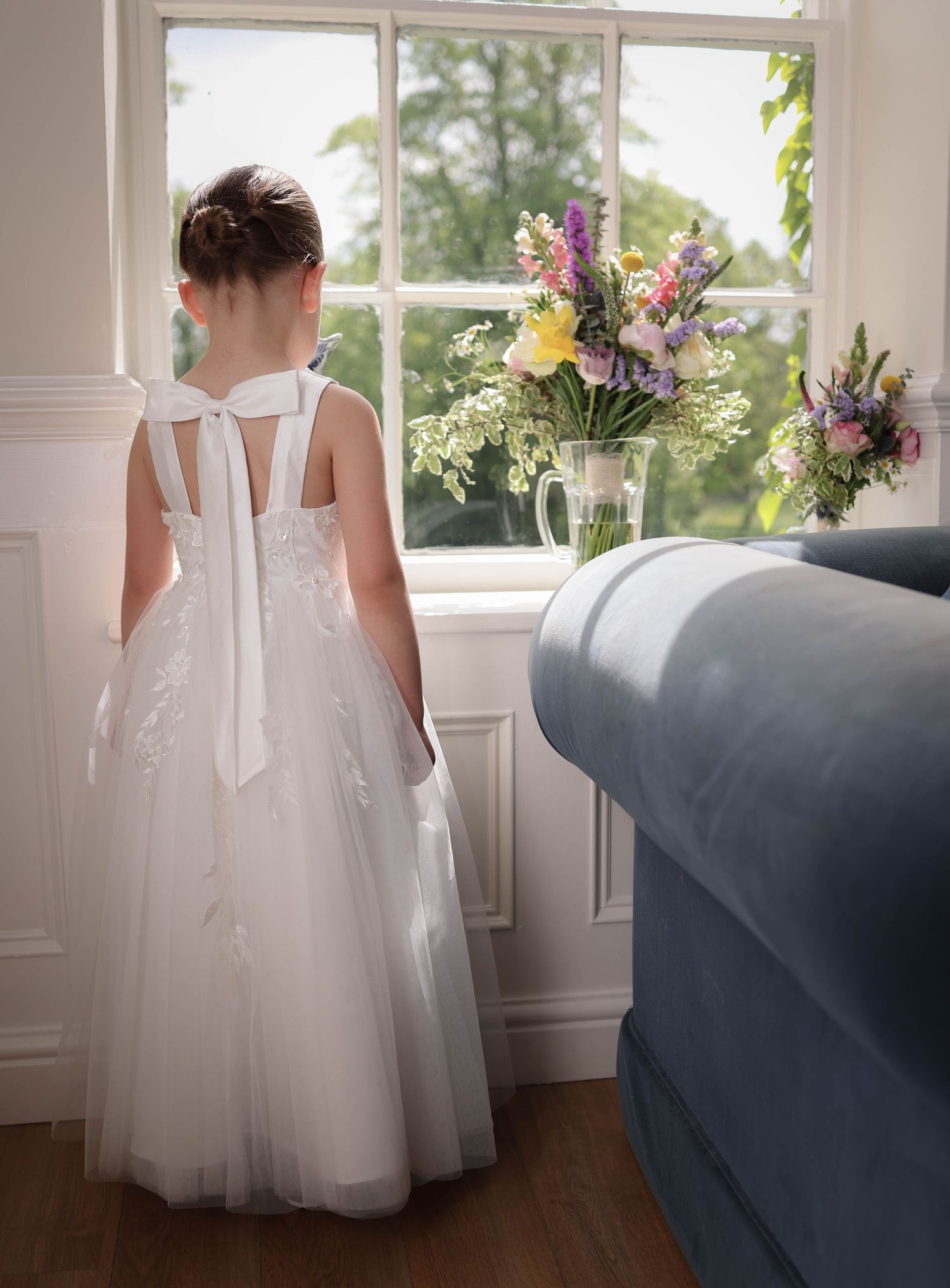Flower girl looking at the brides bouquet. Statham Lodge. Cheshire. Ruby Salmon Photography