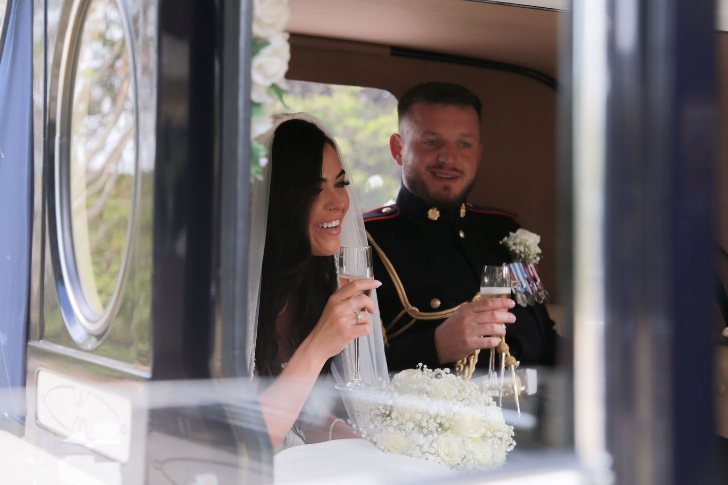Newlyweds sharing a celebratory drink on the way to their reception. Wedding photography by Ruby Salmon Photography.