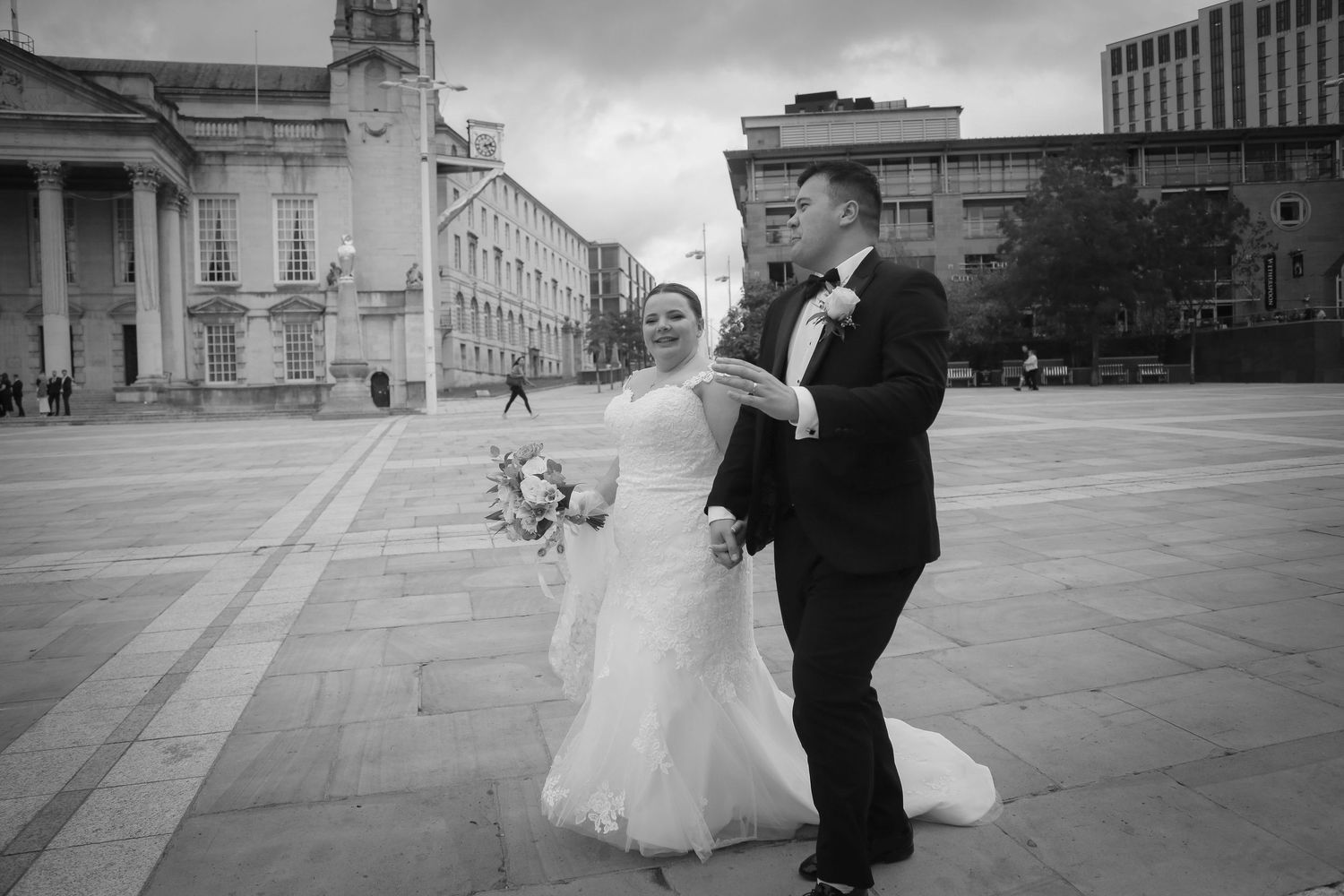 Newlyweds walking in front of The Civic Hall, Leeds. Editorial moments by wedding photographer Ruby Salmon Photography