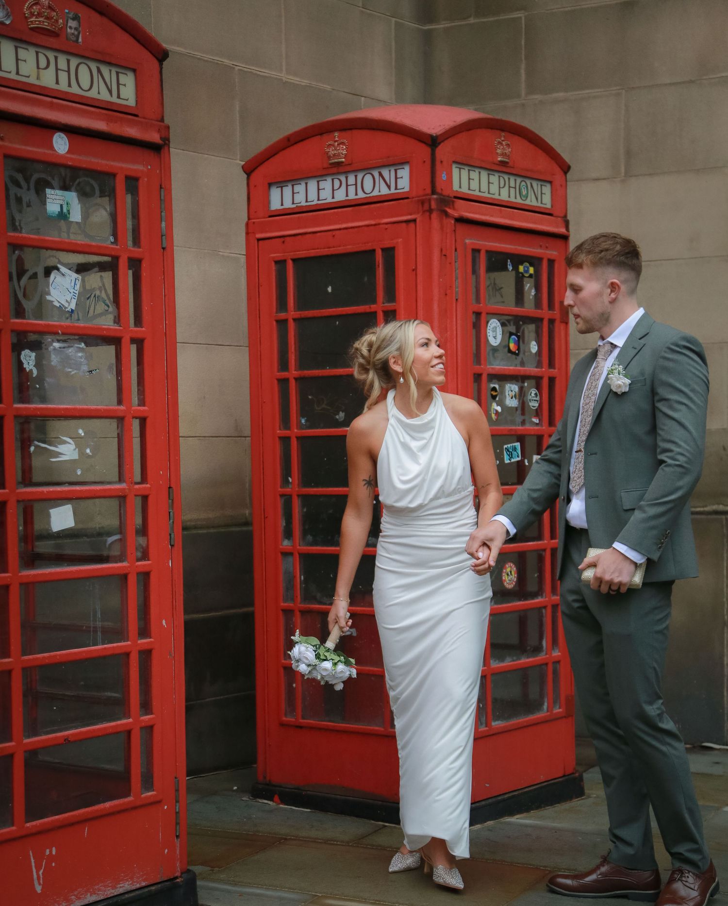Bridal couple in front of telephone box. Manchester elopement. Wedding photography by Ruby Salmon Photography.