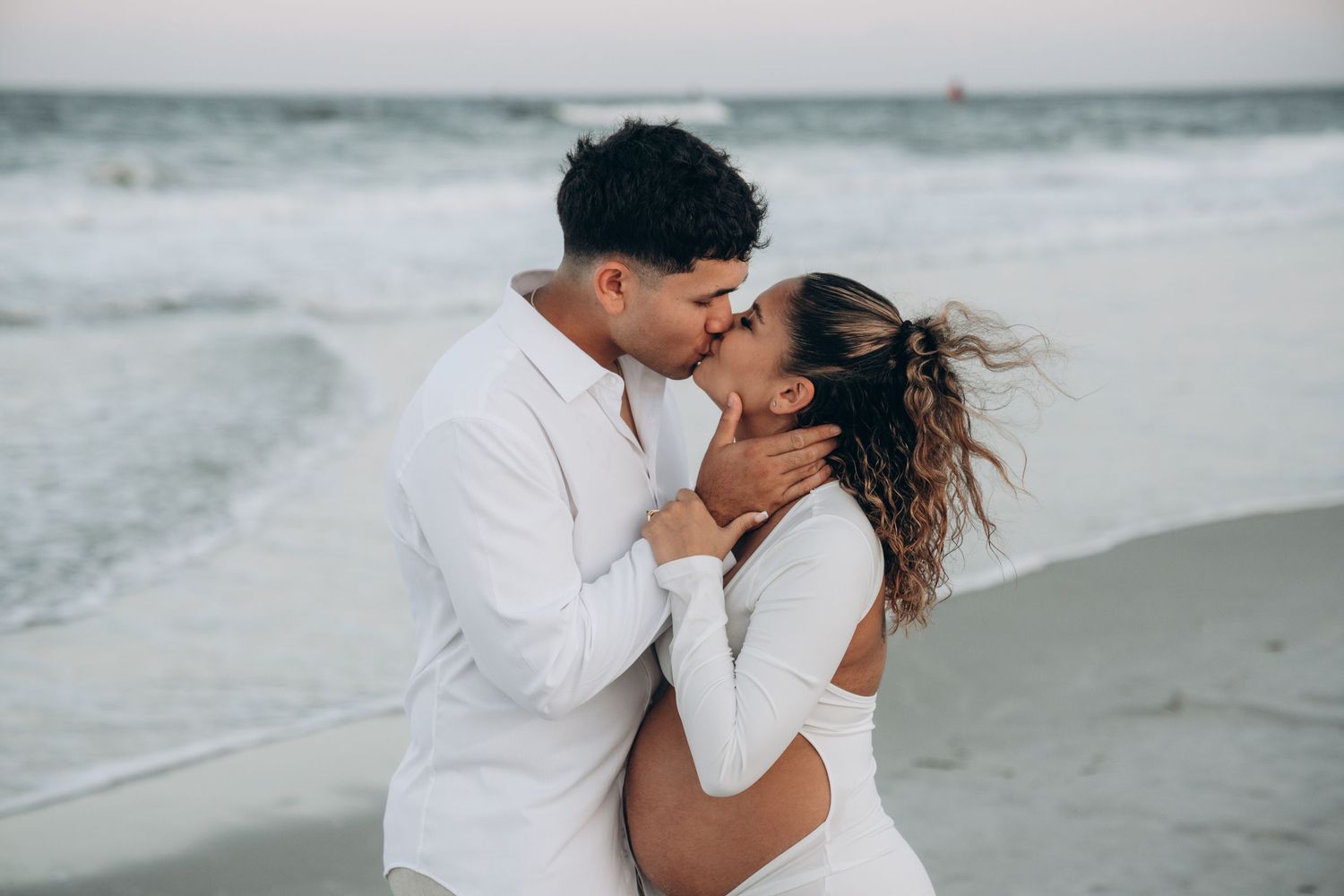 Intimate close-up shots of a couple sharing tender moments on a beach.