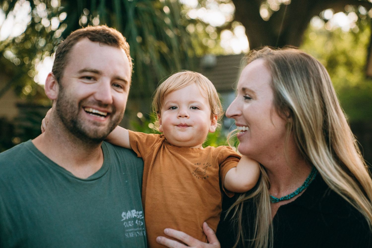 Outdoor family photoshoot capturing genuine smiles and laughter.