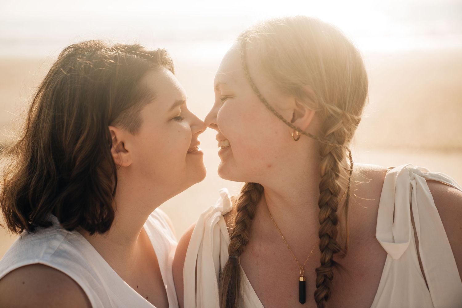 An intimate beach portrait with soft golden lighting.